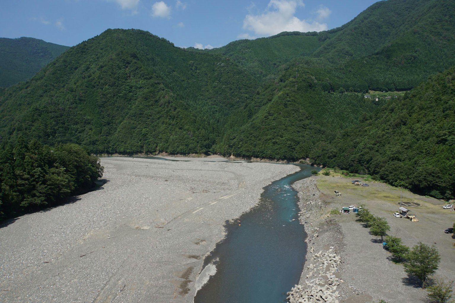 Vista escénica de un río que serpentea entre montañas verdes