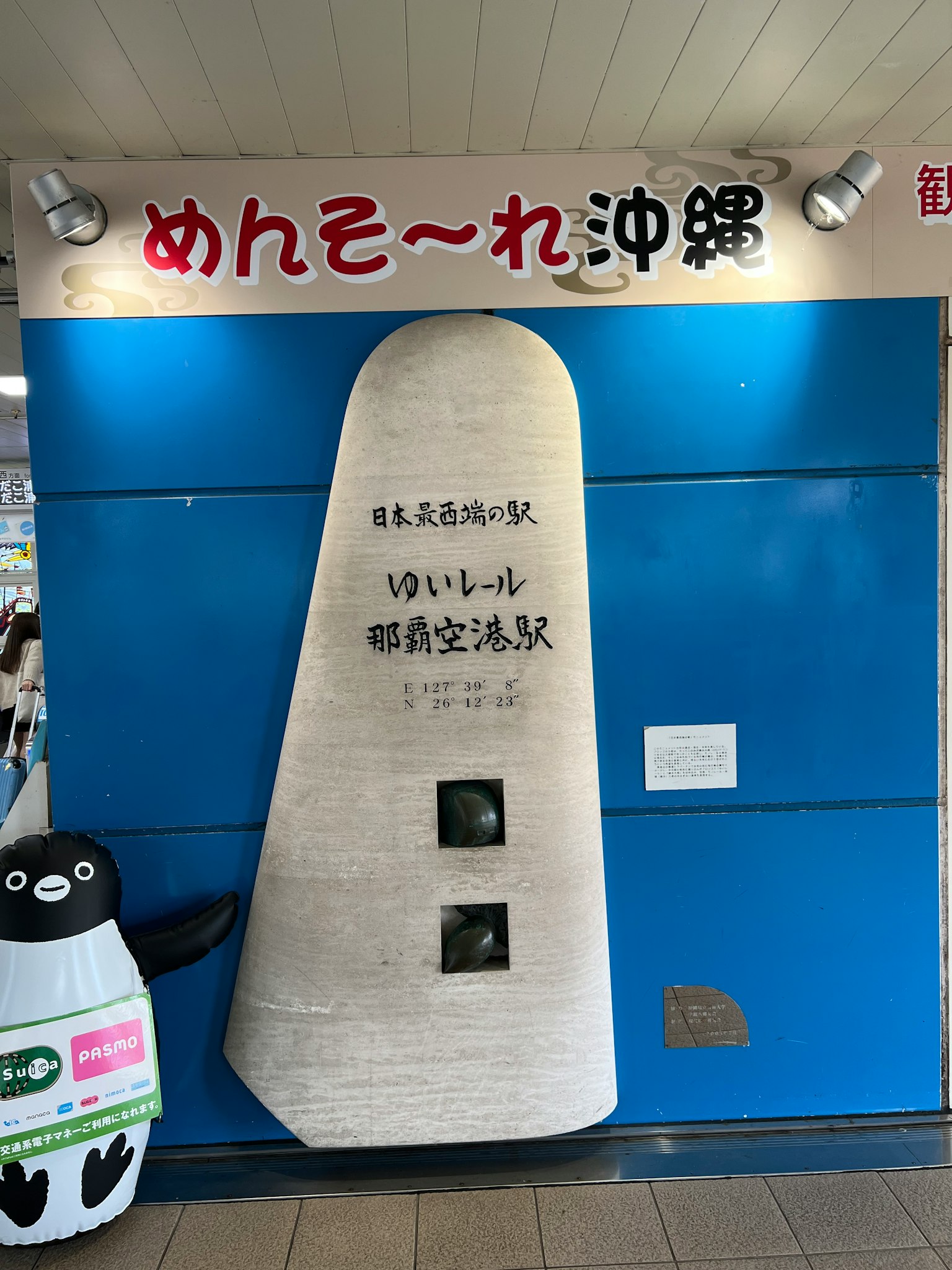 Stone monument on blue wall with penguin character