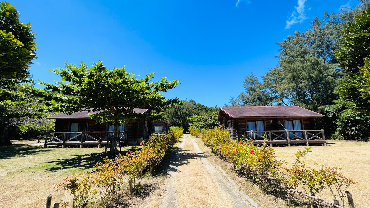 藍天下兩座小屋和一條砂石小路的風景