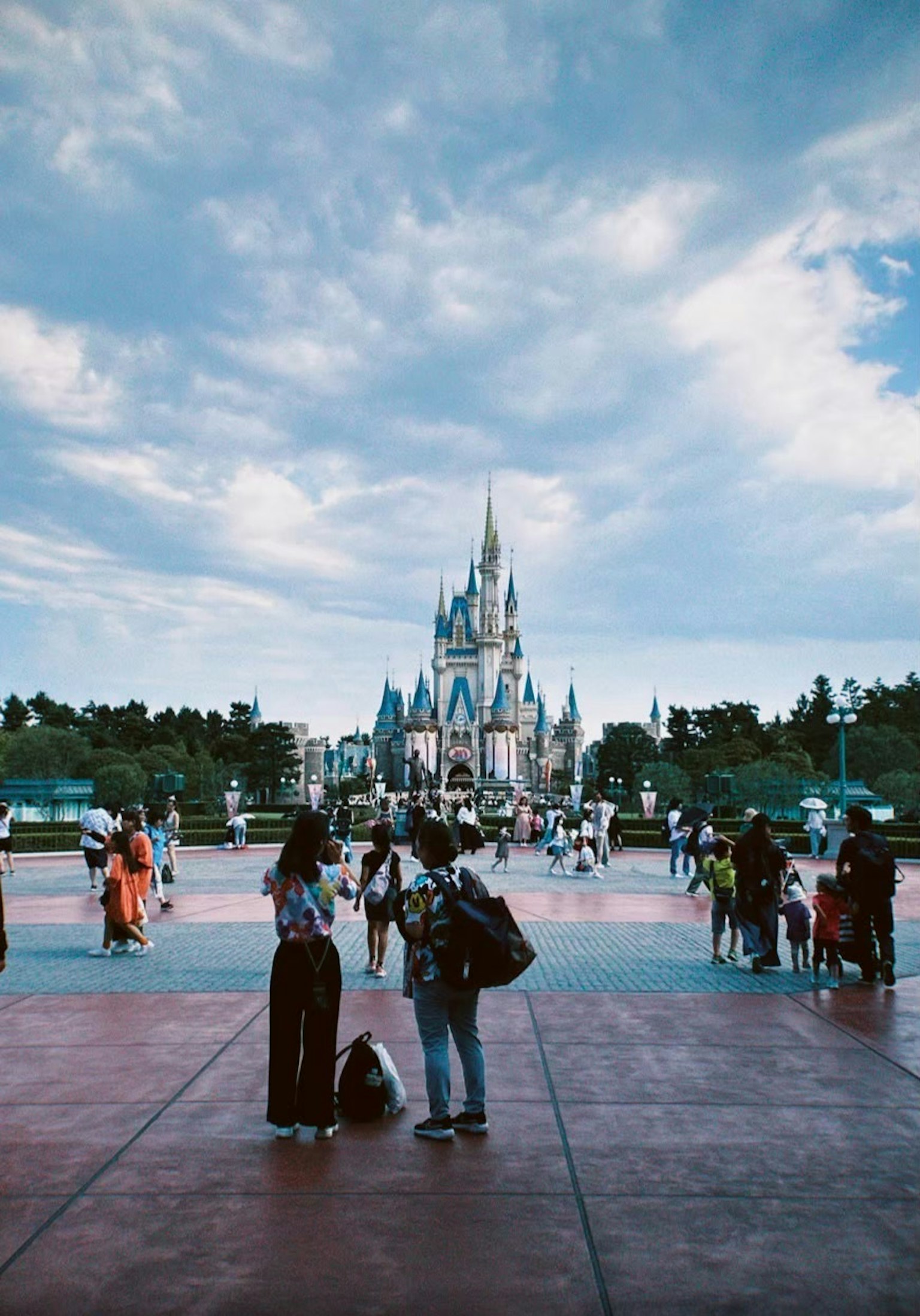 Una piazza affollata con il castello di Disney sullo sfondo