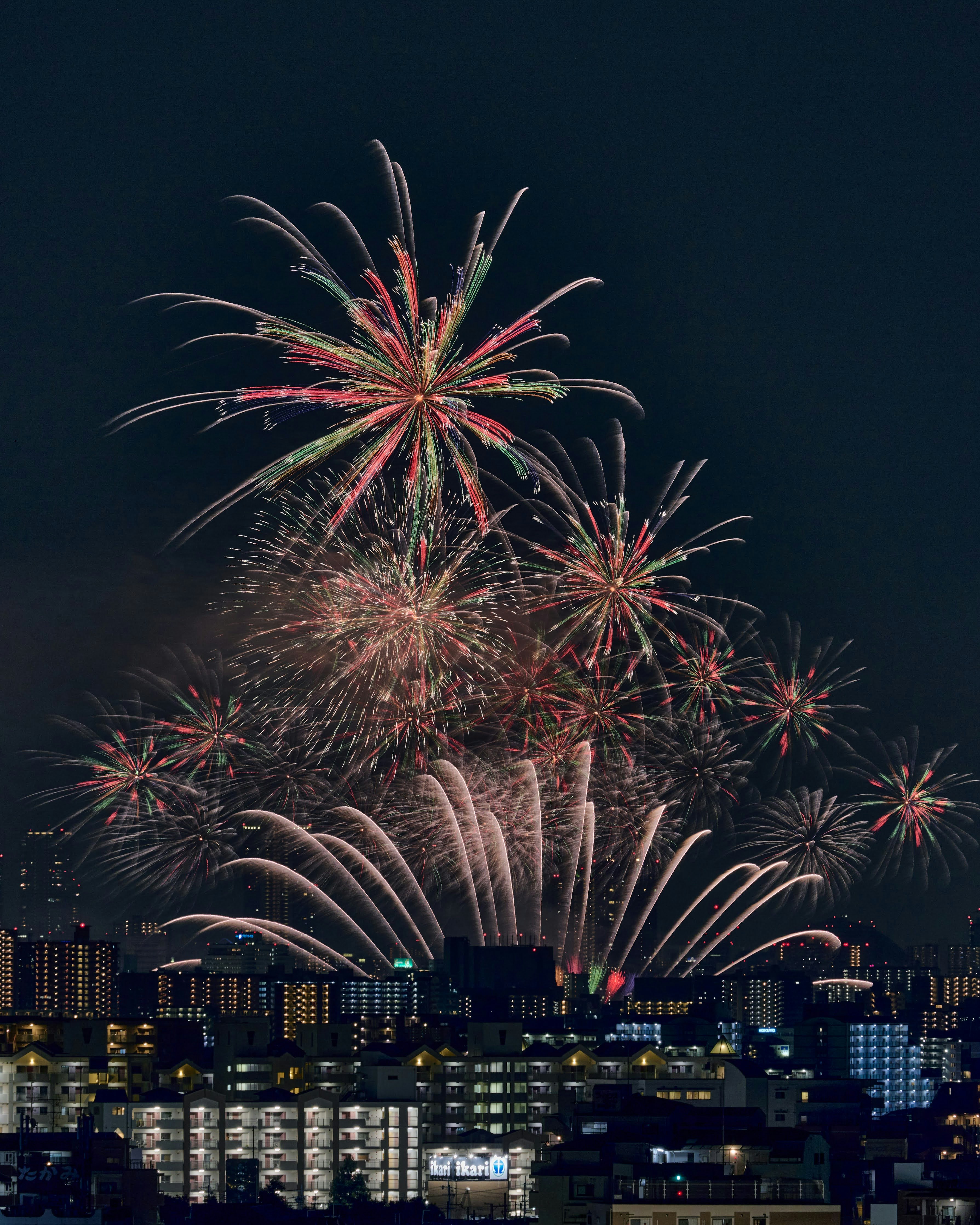 夜空に打ち上がる花火と街の灯り