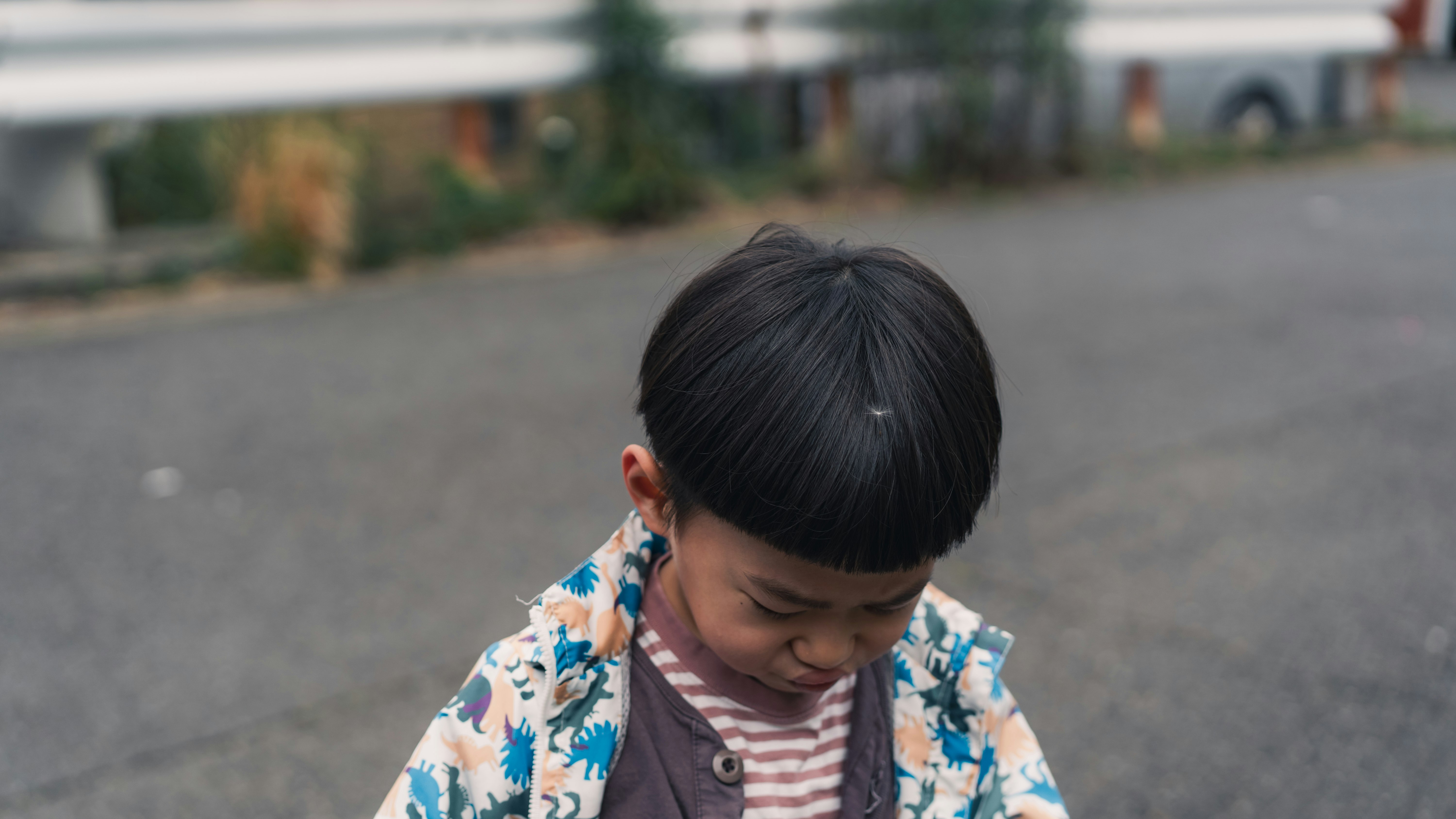 子どもが路上でうつむいている