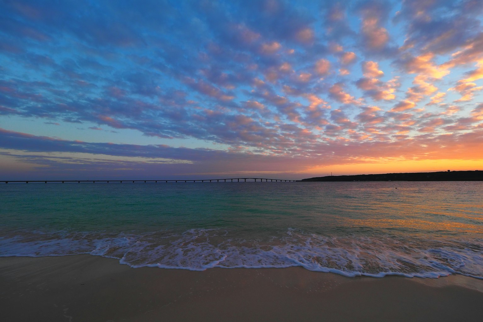 Beautiful beach scene with a sunset colorful clouds in the sky