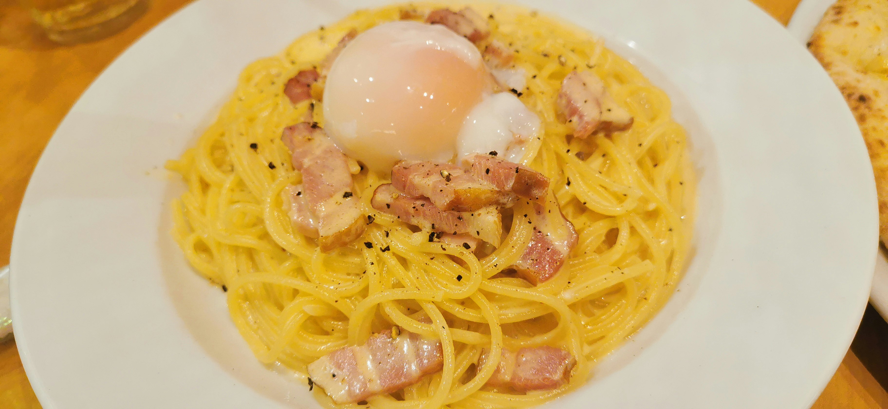 plate of carbonara-style spaghetti with a runny egg yolk