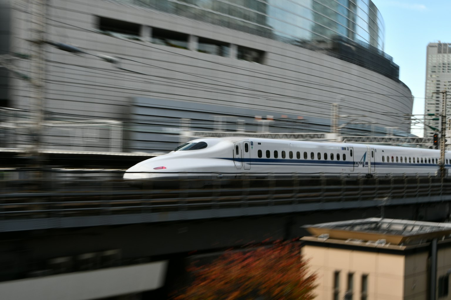 Shinkansen chạy nhanh qua các tòa nhà hiện đại trong bối cảnh đô thị