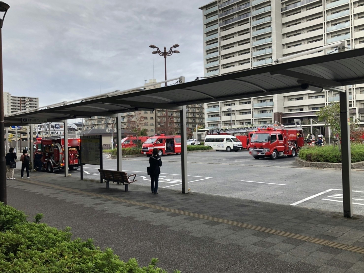 Bus stop and waiting area in front of a station with buses lined up