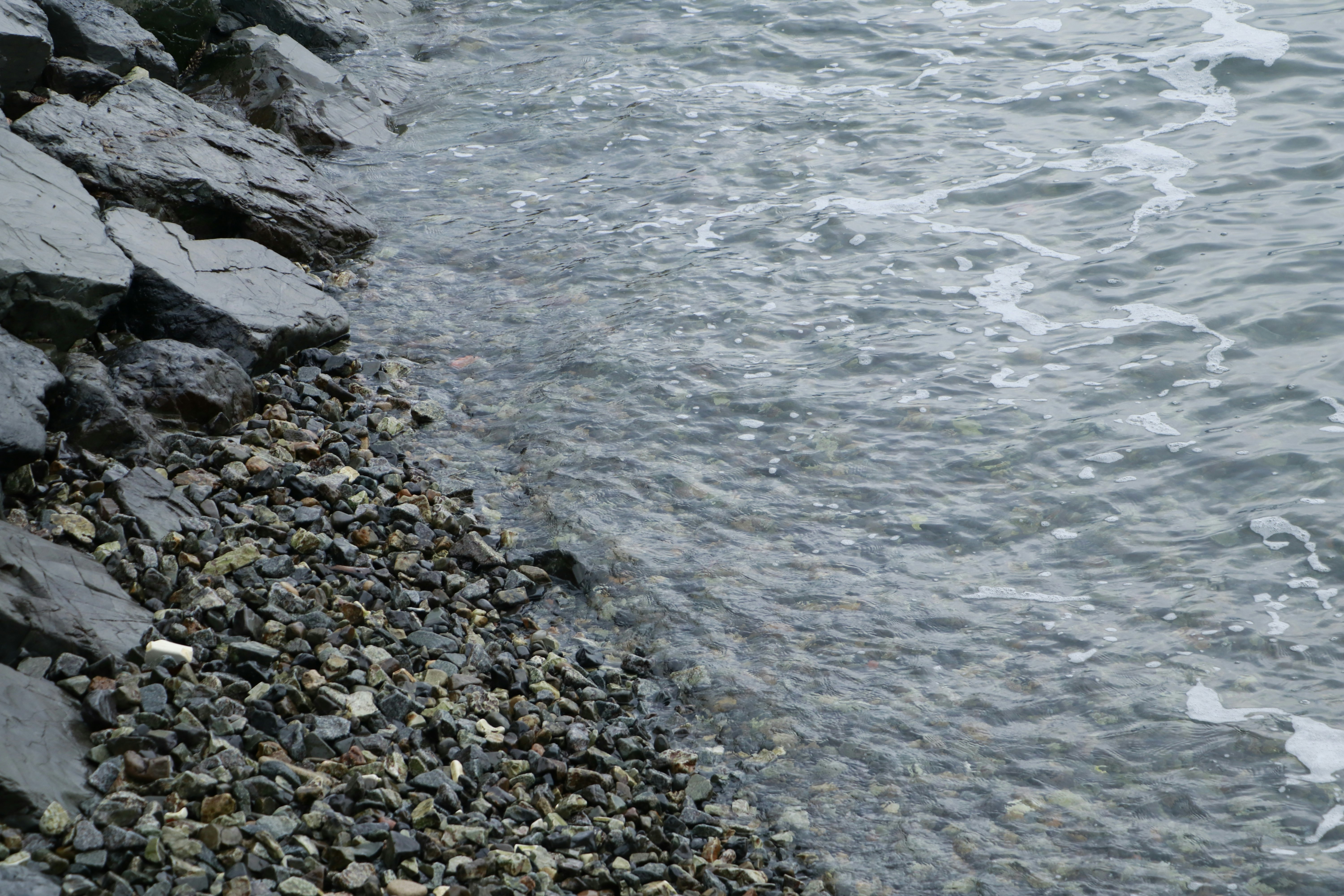 岩石海岸的卵石与海浪