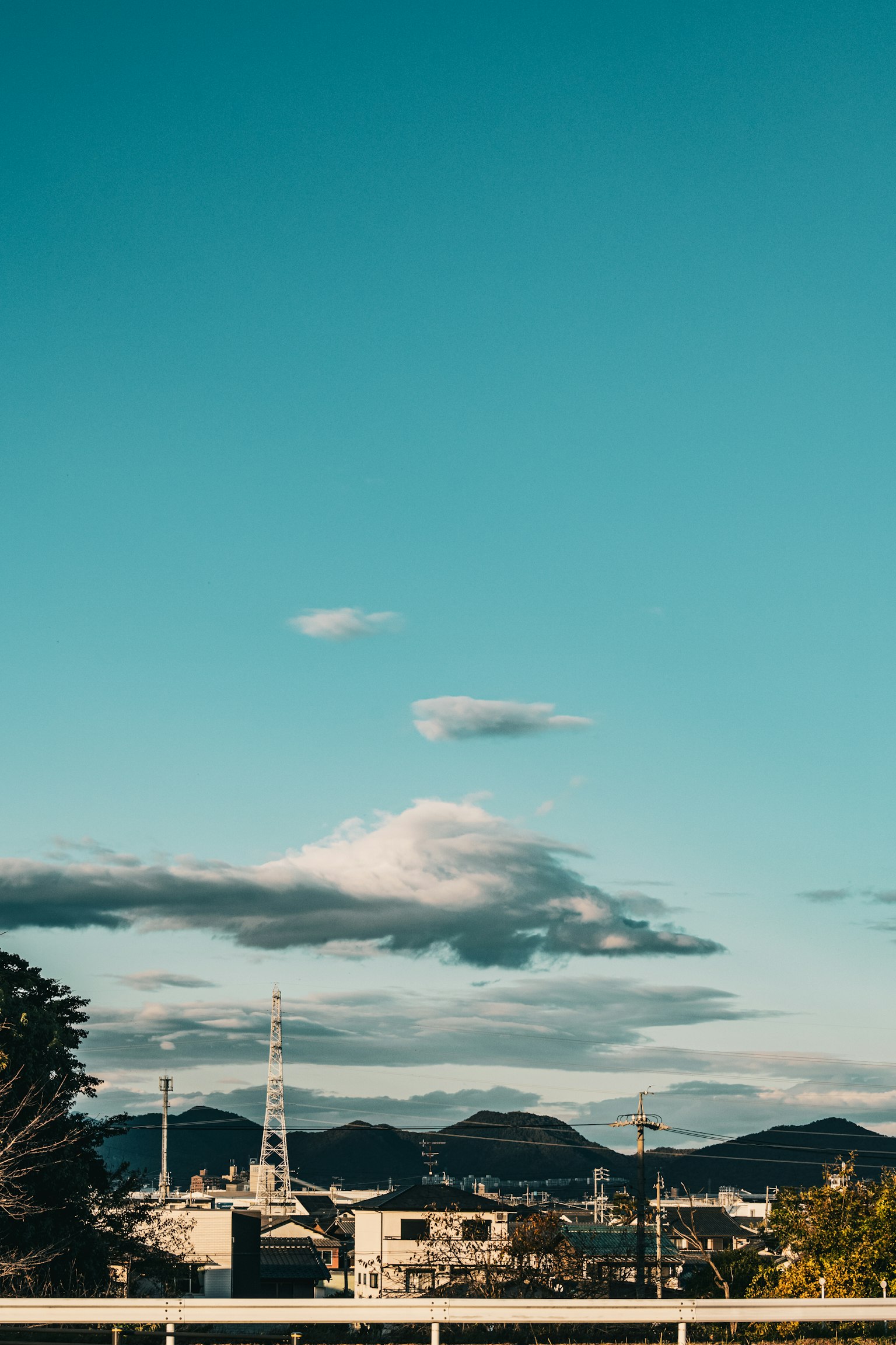 Paysage avec ciel bleu et nuages présentant des montagnes et silhouette de ville
