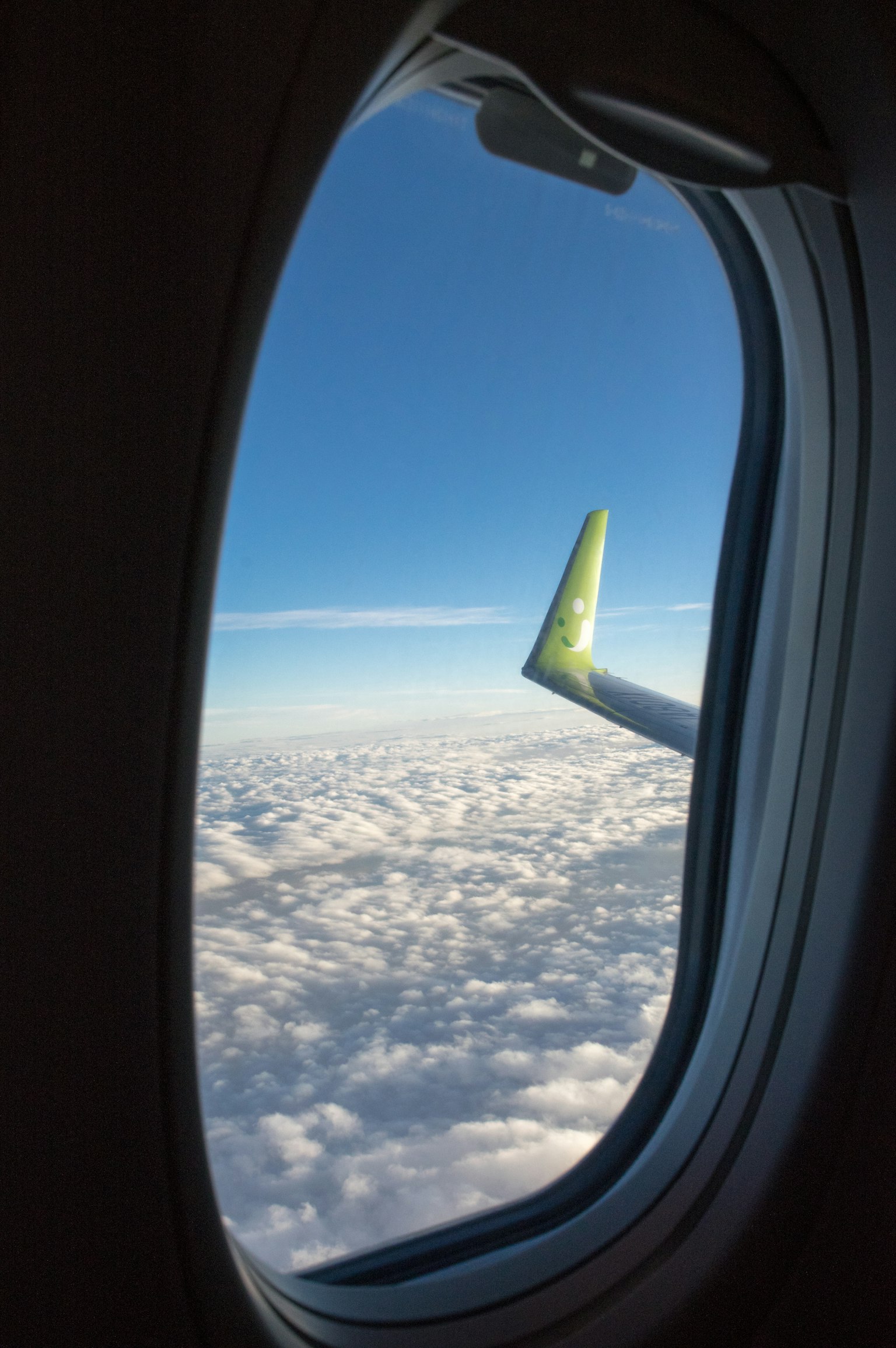 View of clouds and blue sky from an airplane window