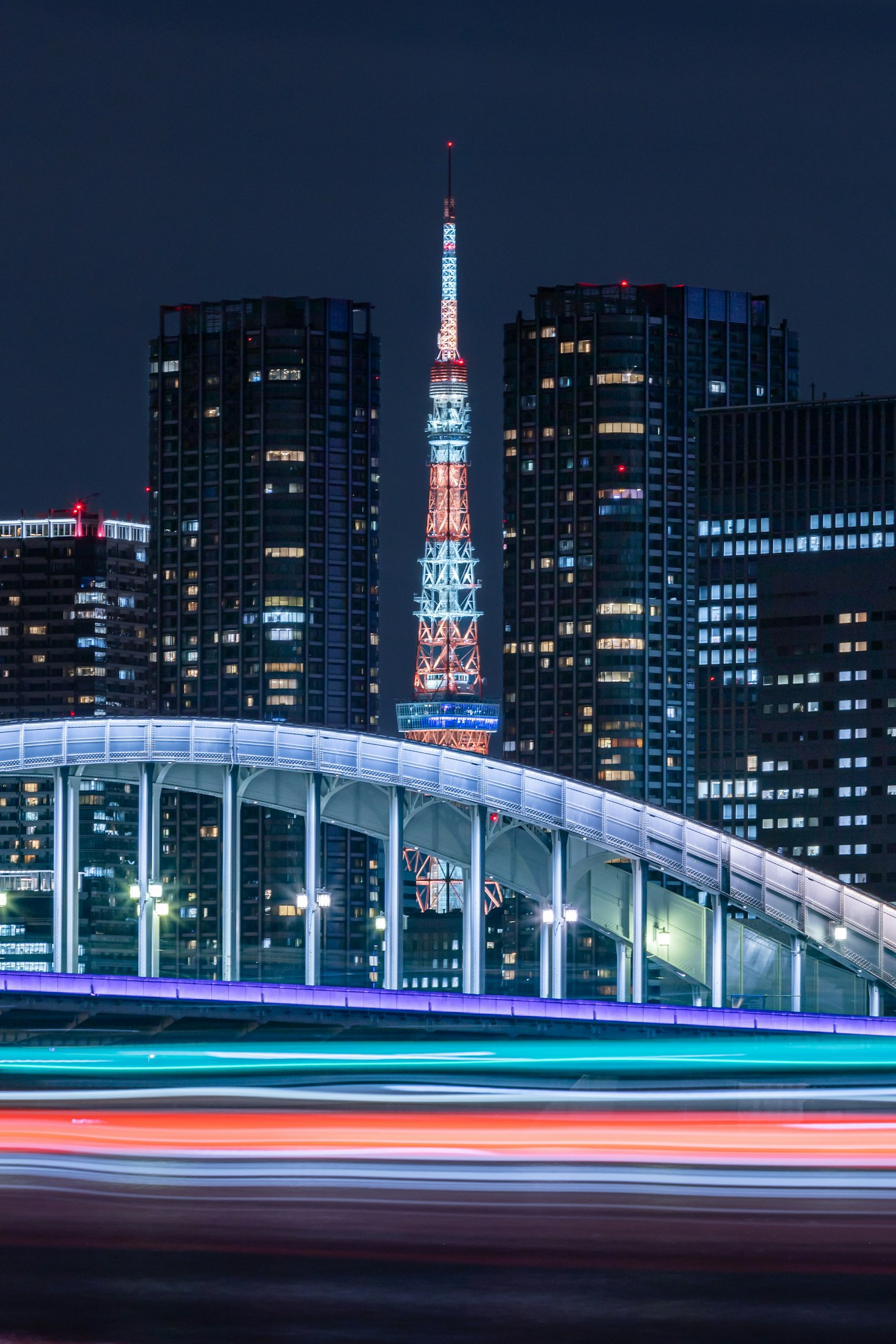 Foto de la Torre de Tokio con un puente y el horizonte de la ciudad de noche