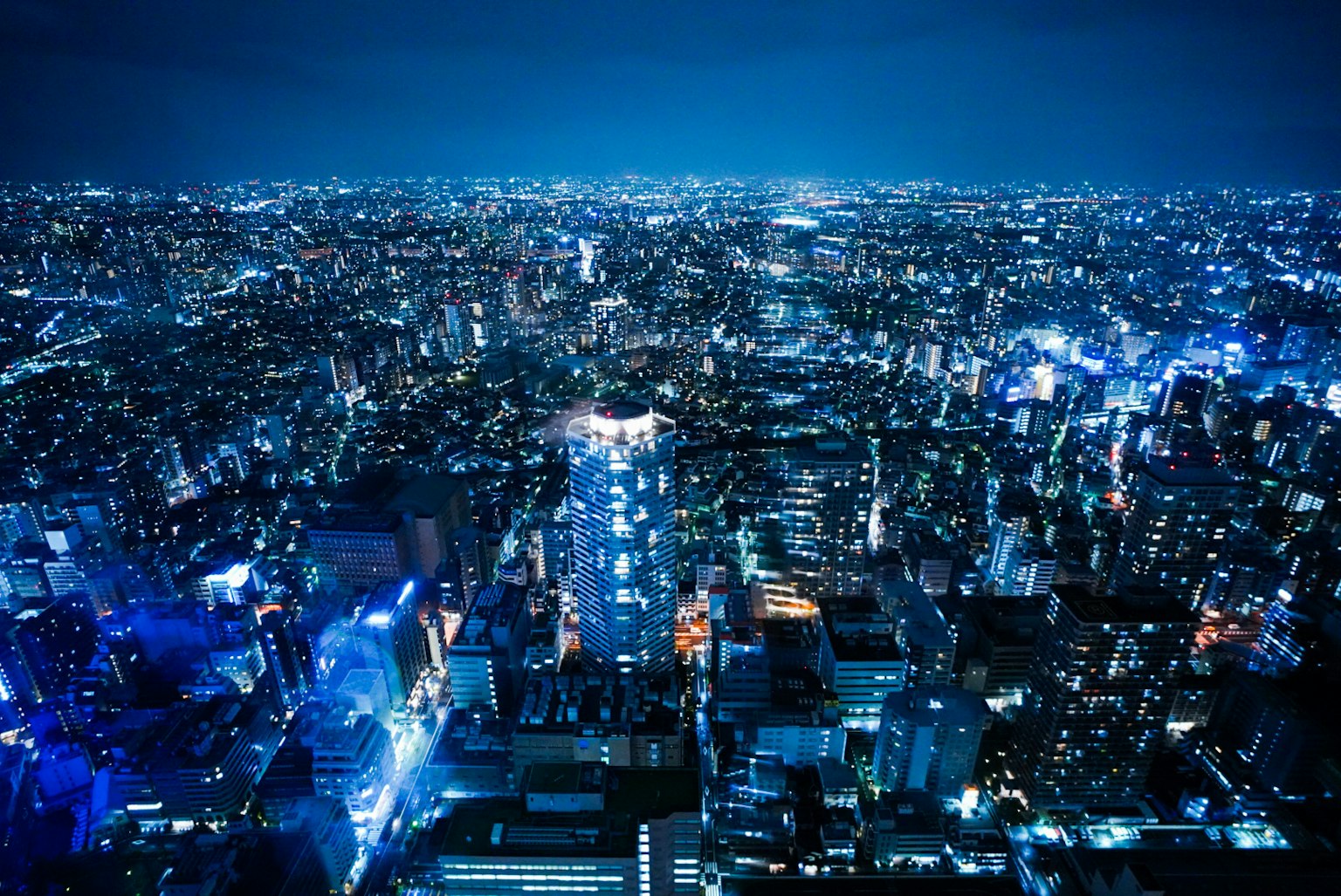 Amplio paisaje urbano de Tokio de noche iluminado por luces azules