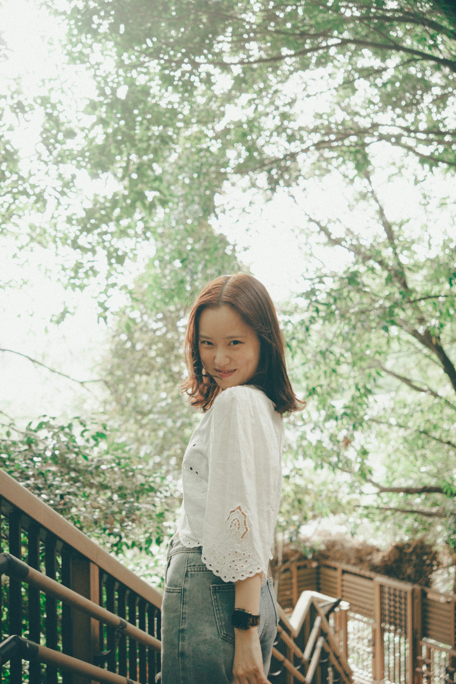 Portrait d'une femme souriante parmi des arbres verts