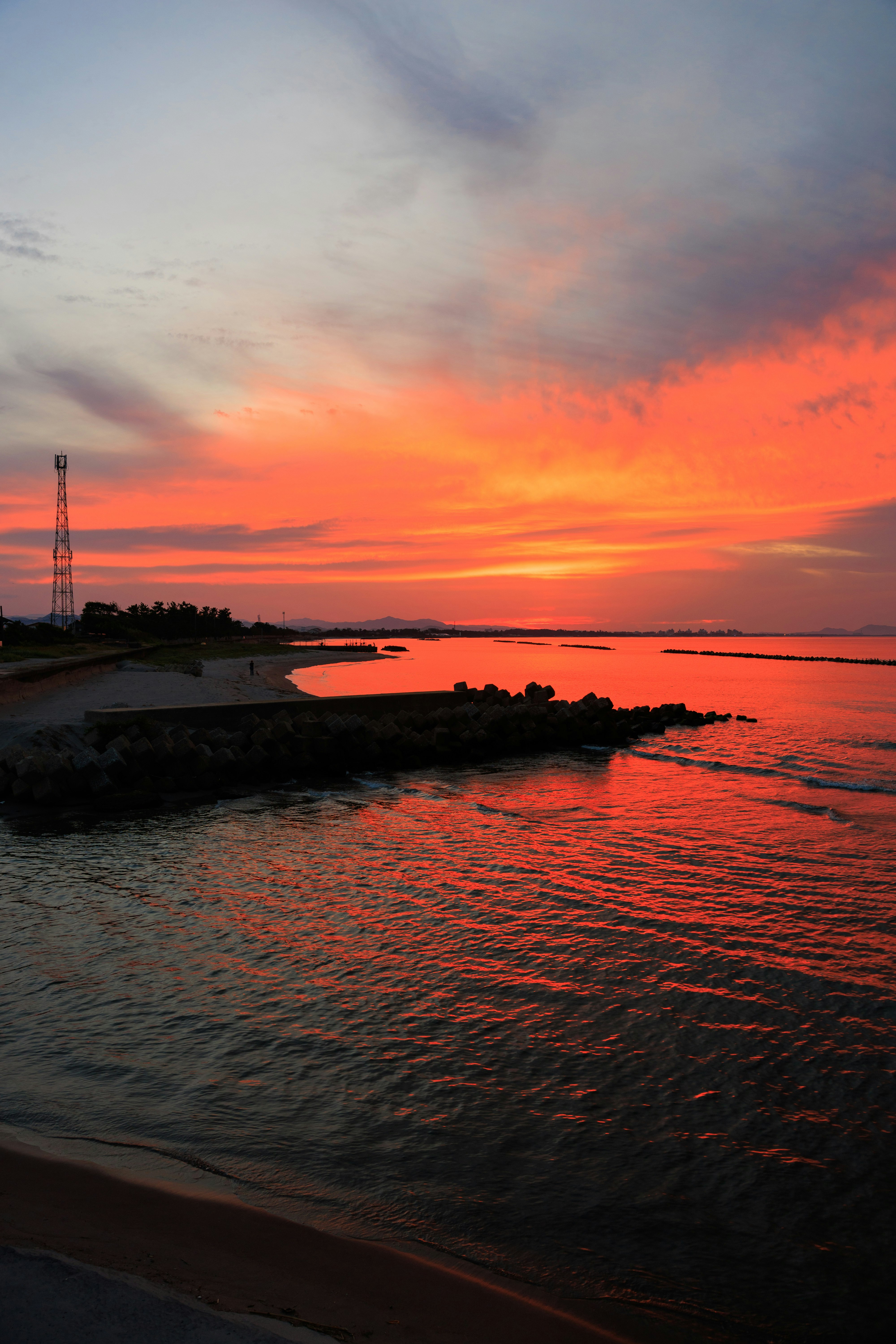 Sonnenuntergang an der Küste, wo ein Fluss auf den Strand trifft