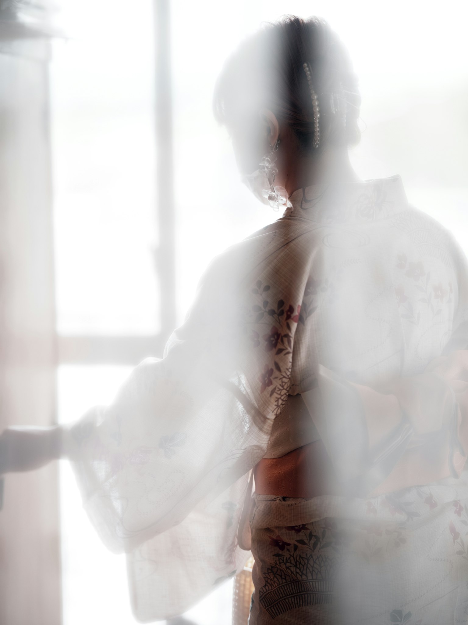 Bóng dáng của một người phụ nữ trong kimono đứng sau vải mỏng