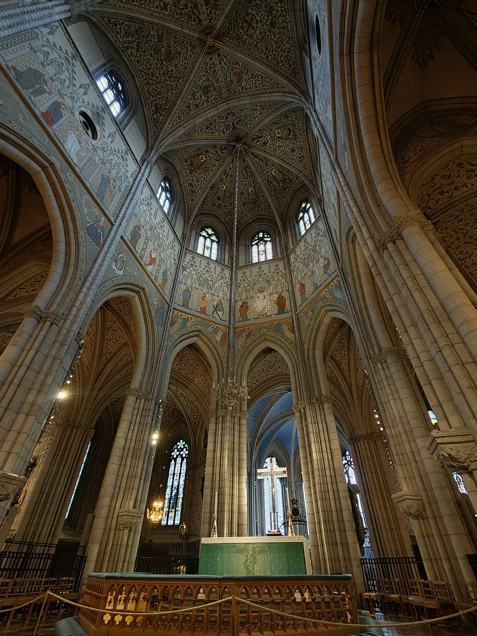 Interno di una chiesa splendida con soffitti alti a volta e affreschi colorati con un altare centrale a croce