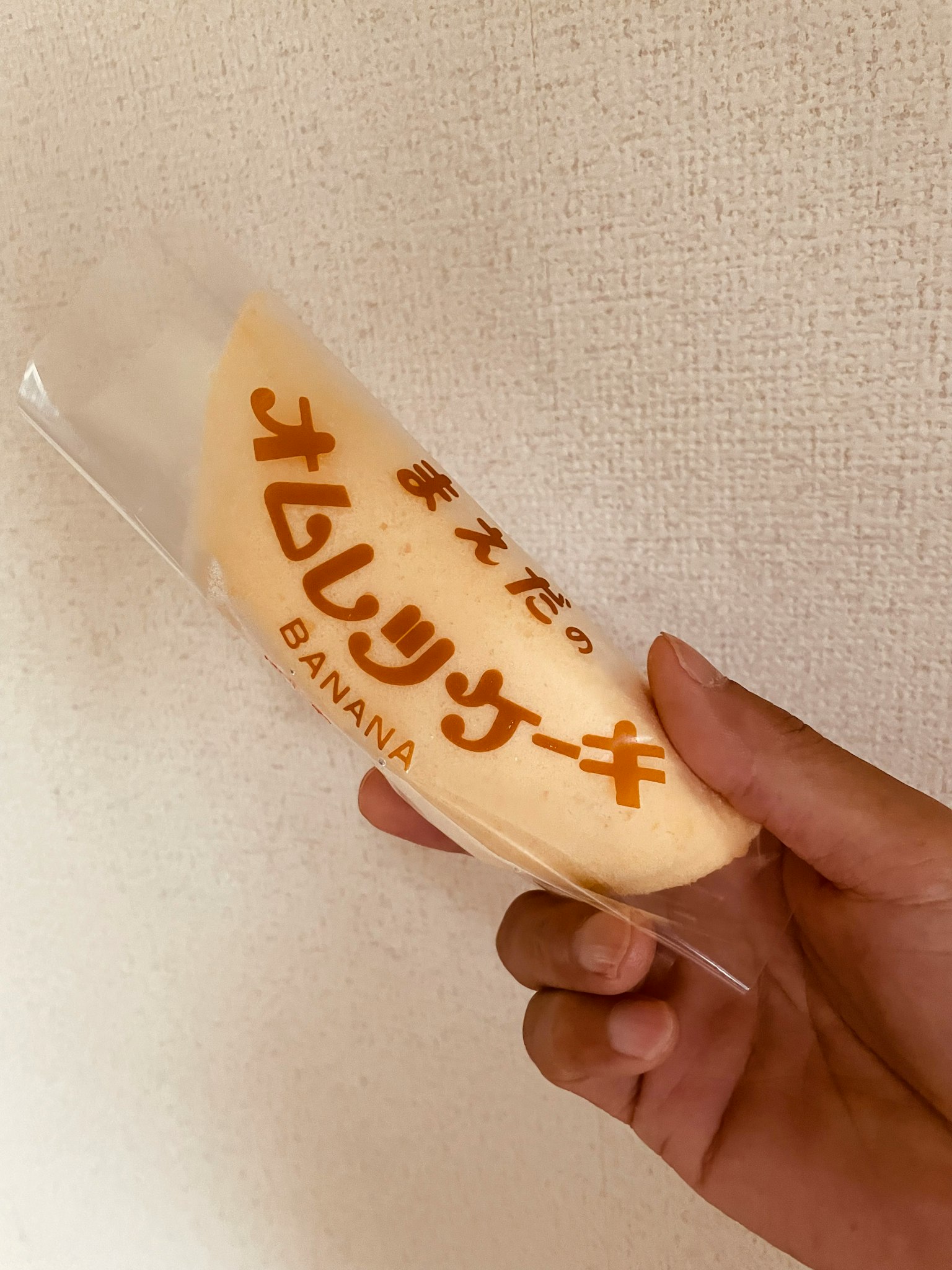Una mano che tiene un pacchetto di torta omelette