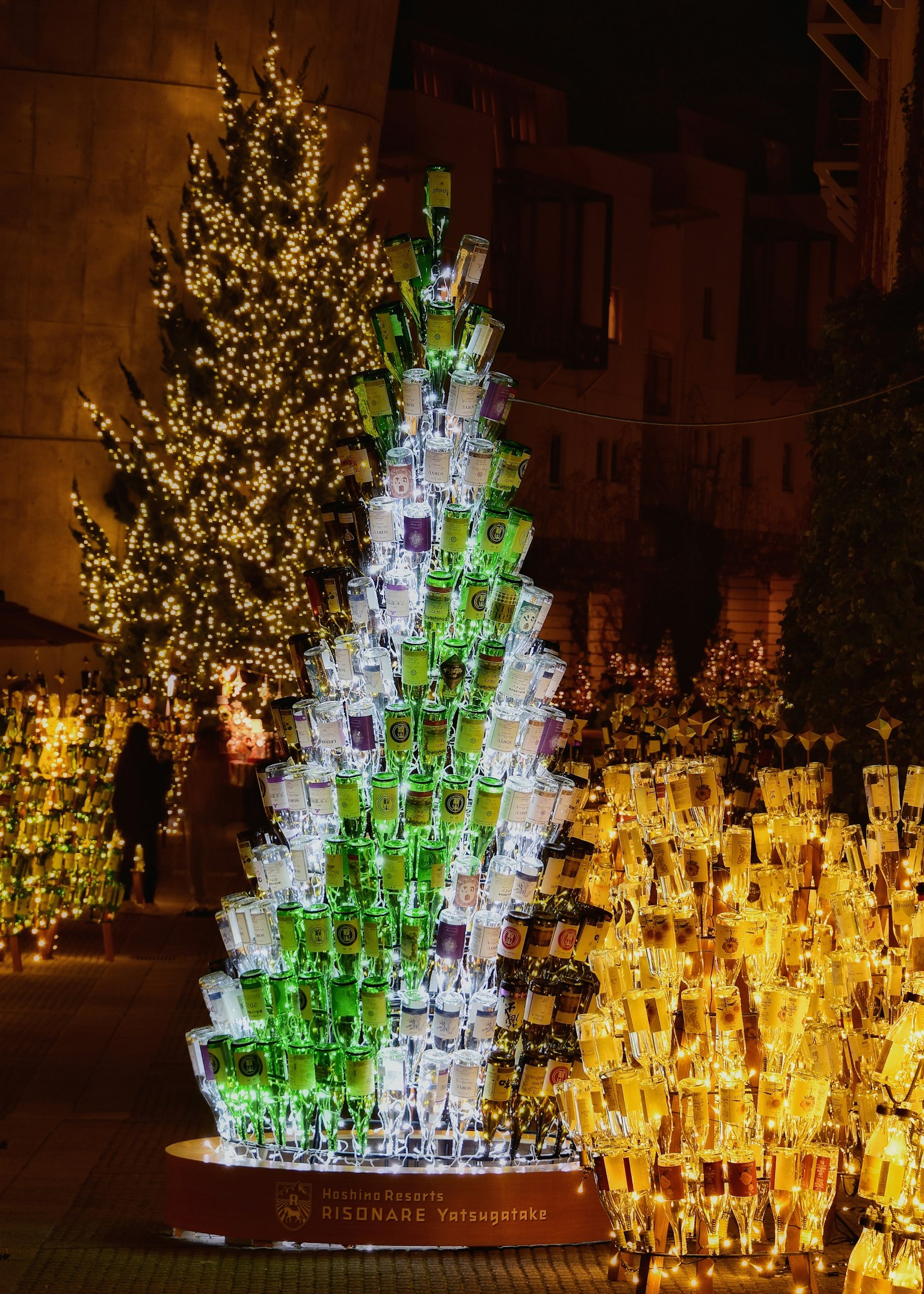 Bunt beleuchteter Weihnachtsbaum umgeben von leuchtenden Dekorationen