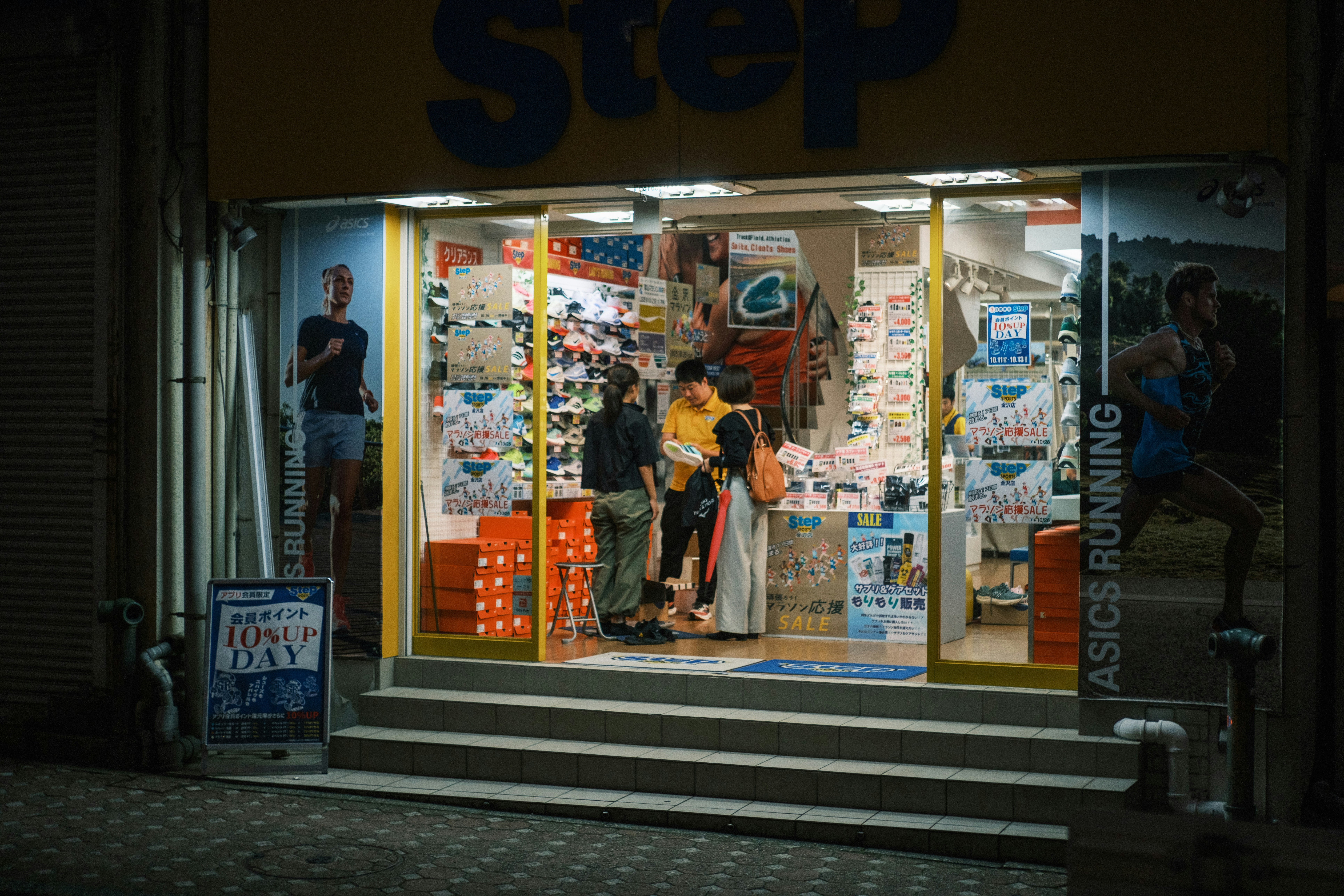 scena notturna in strada davanti alla vetrina di un negozio di scarpe