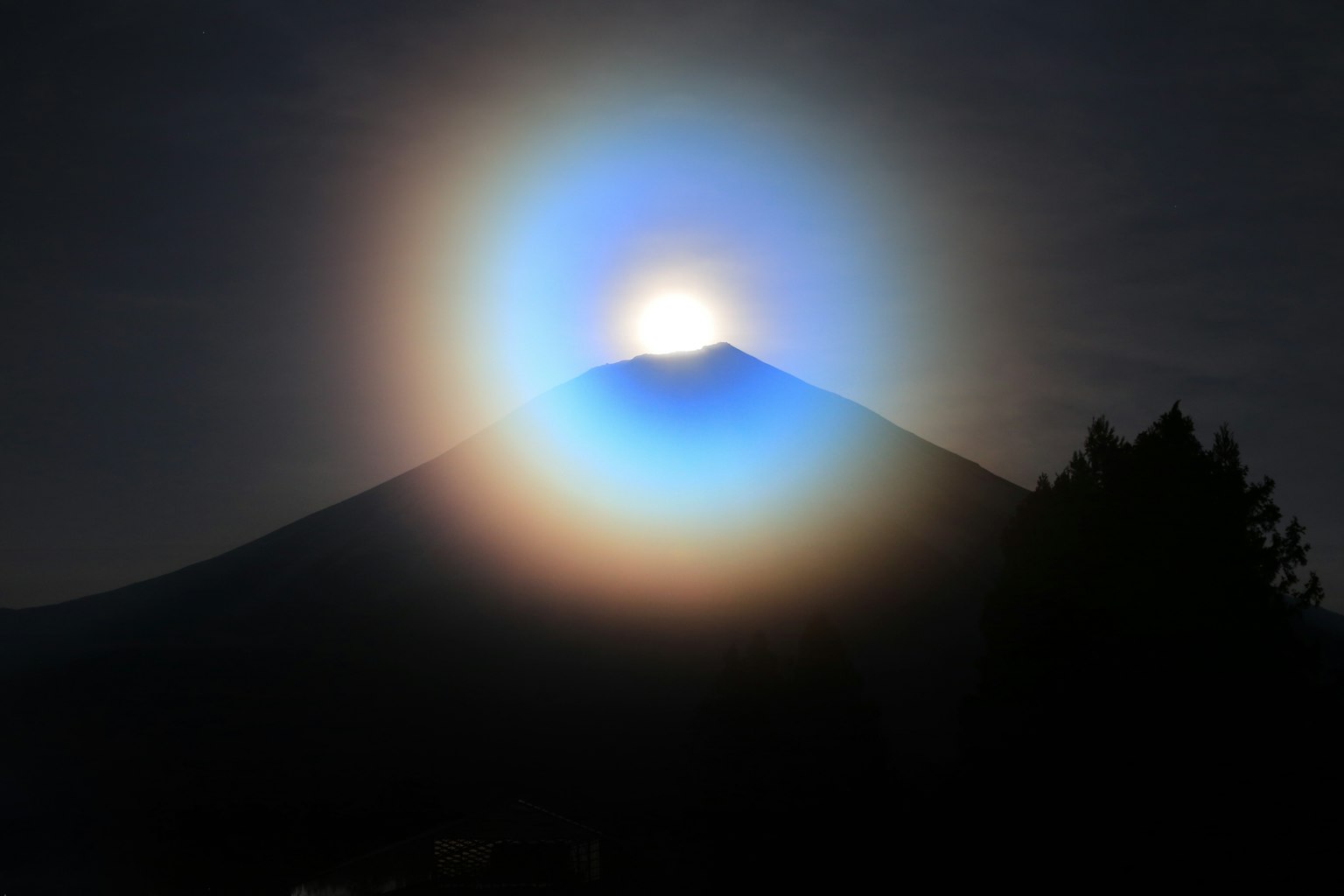 夜空中富士山的轮廓被发光的蓝色光环照亮