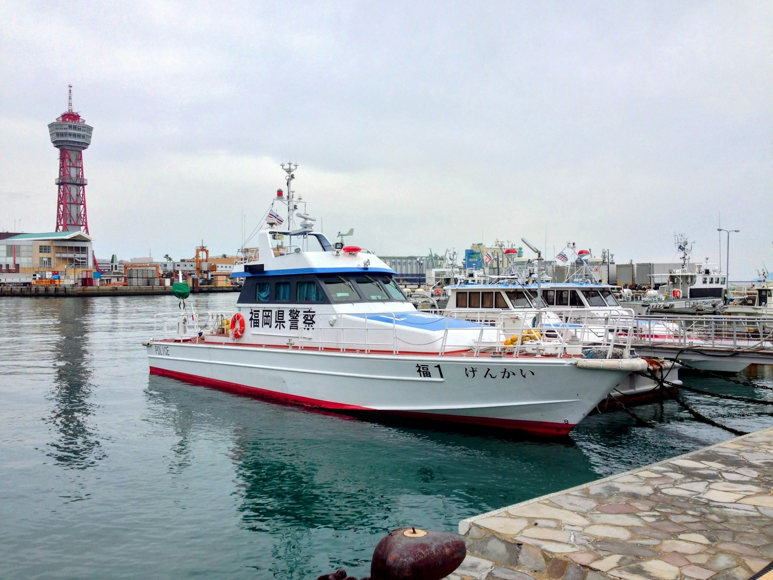 Ein weißes und rotes Boot im Hafen mit der umliegenden Landschaft
