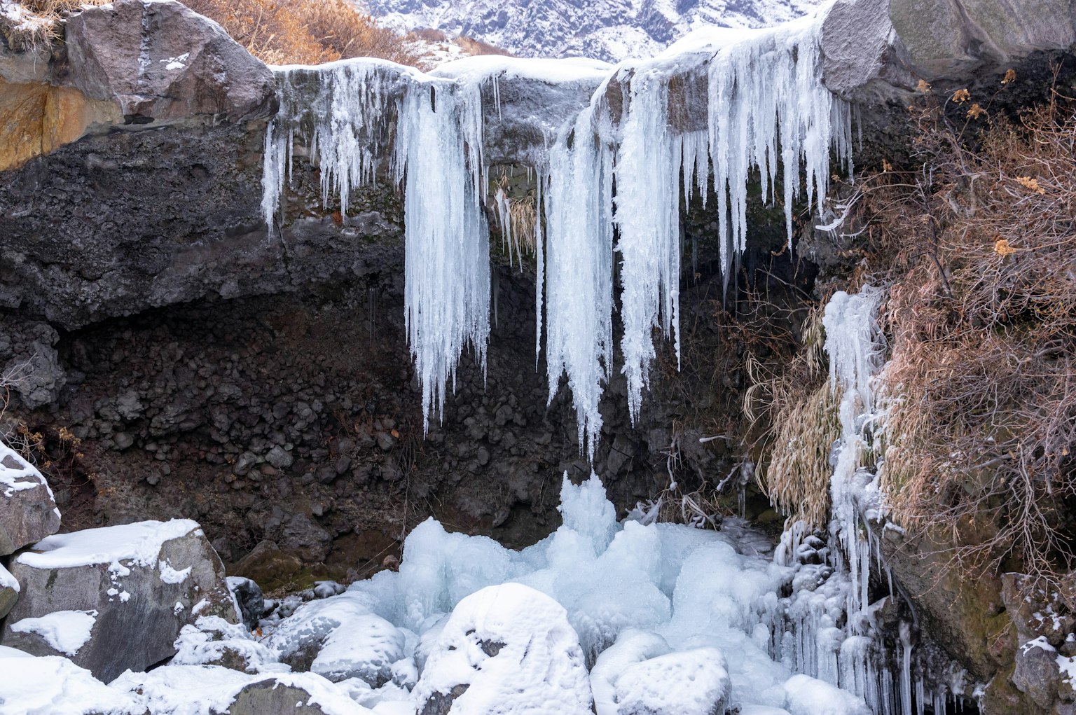 Ghiaccioli appesi a una sporgenza rocciosa in un paesaggio invernale