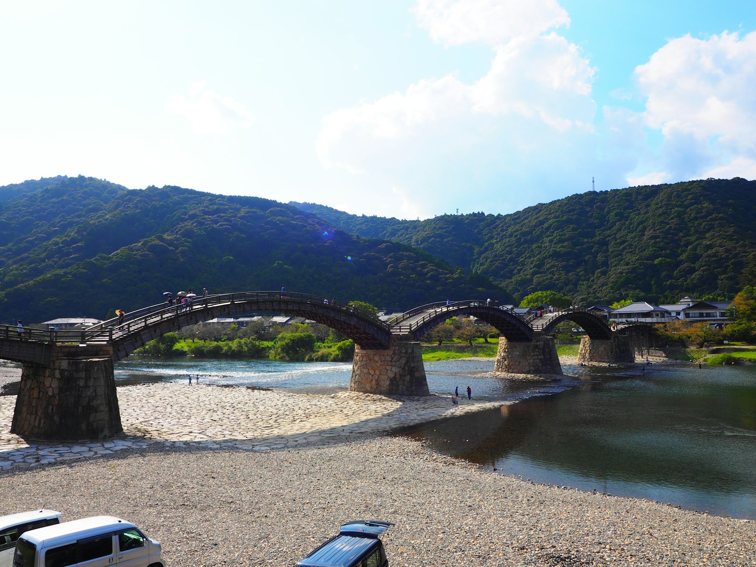 Pont en bois en arc avec des montagnes en arrière-plan