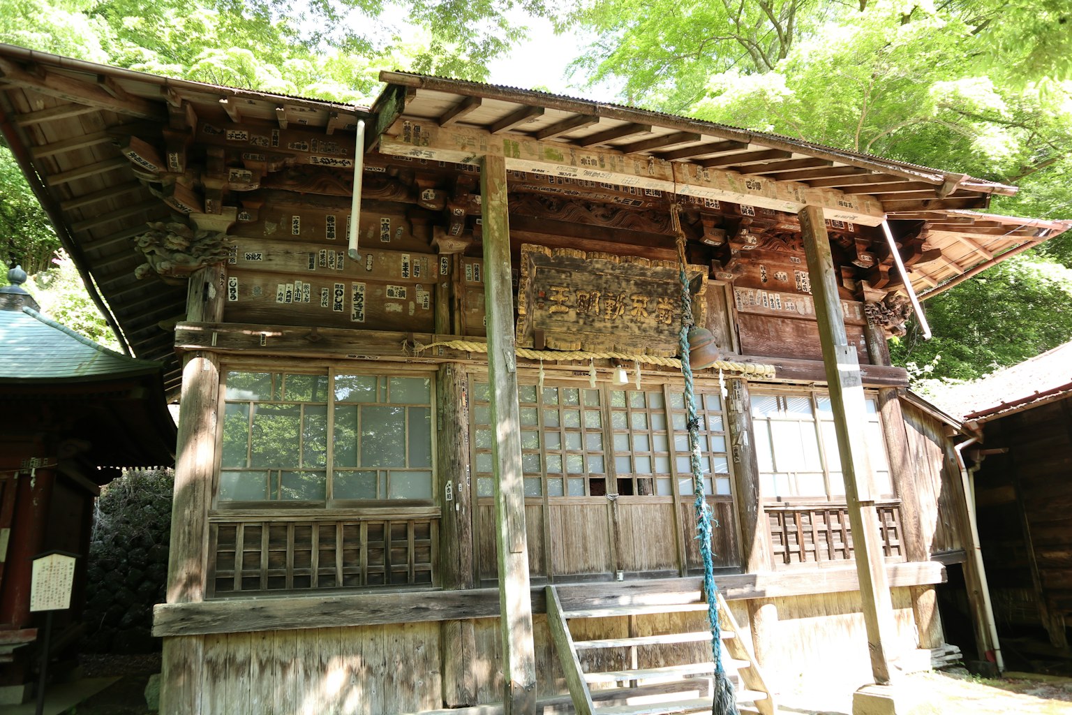 Old wooden house with a wooden roof surrounded by greenery