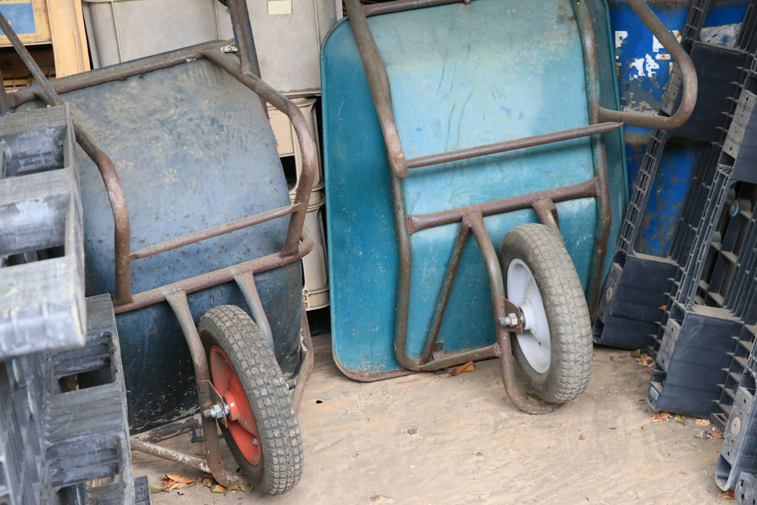 Two different colored wheelbarrows side by side