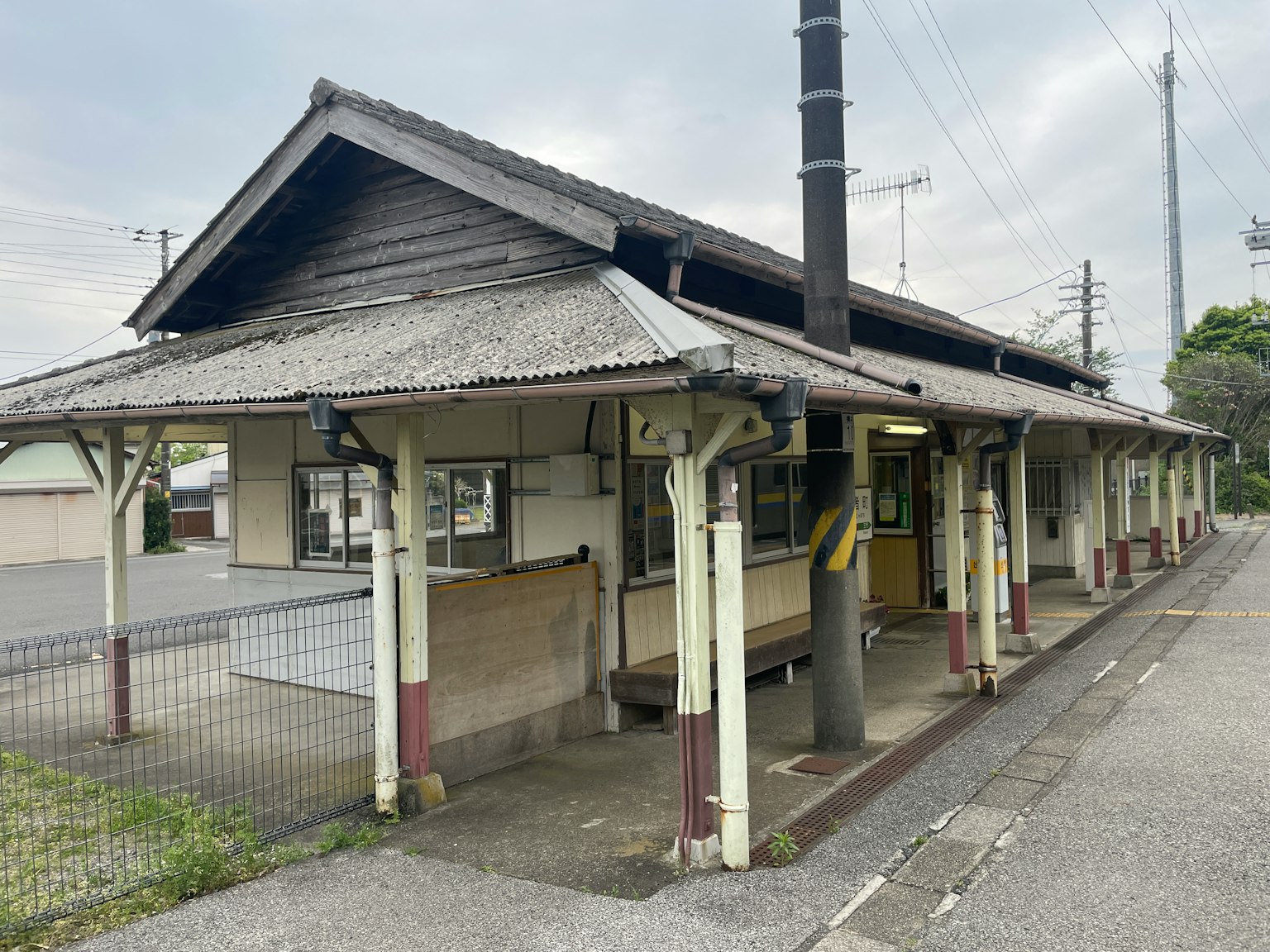 Vue extérieure d'une vieille gare avec une structure en bois et un quai