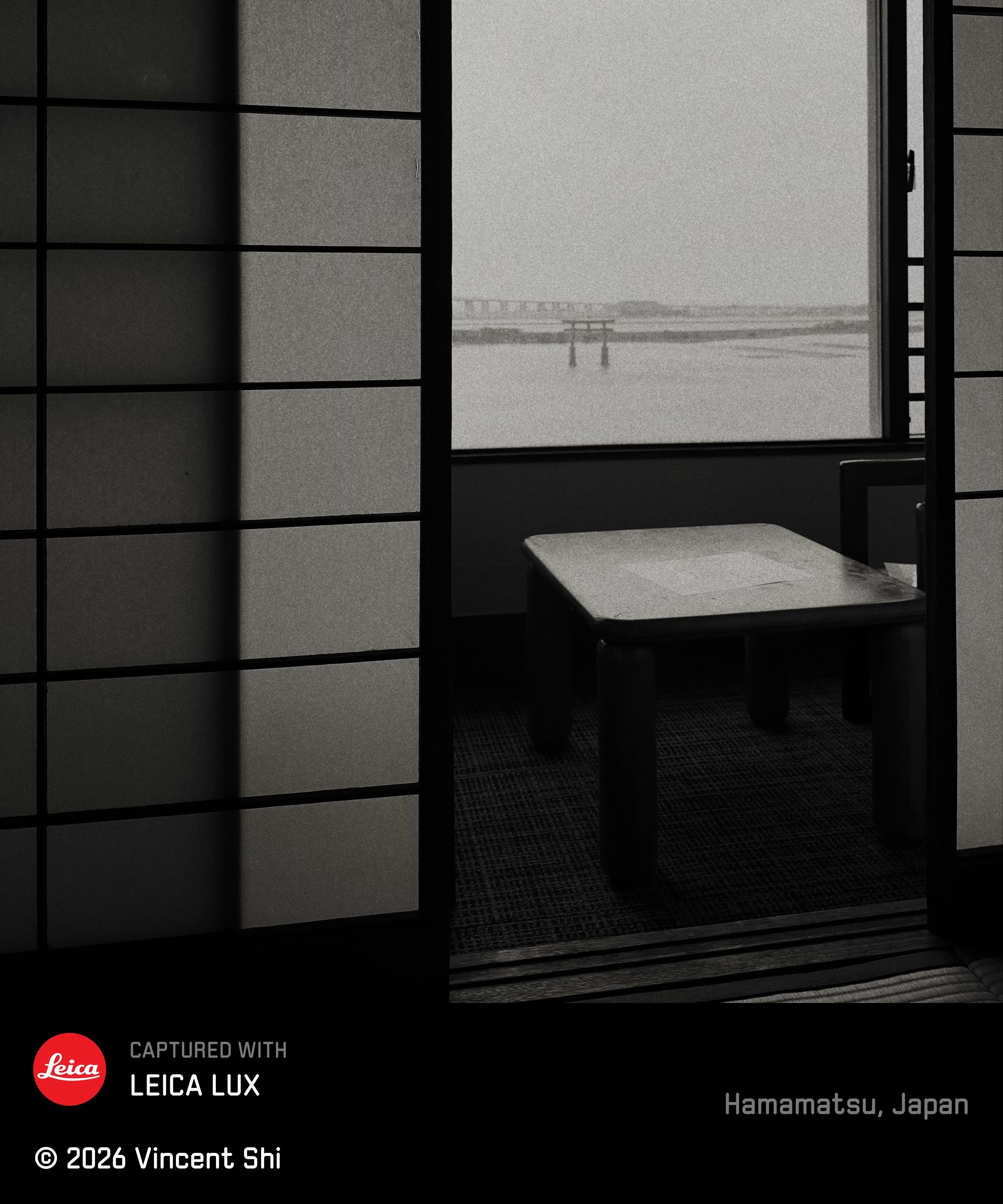 Indoor view with a small table and a grid window looking out to the sea