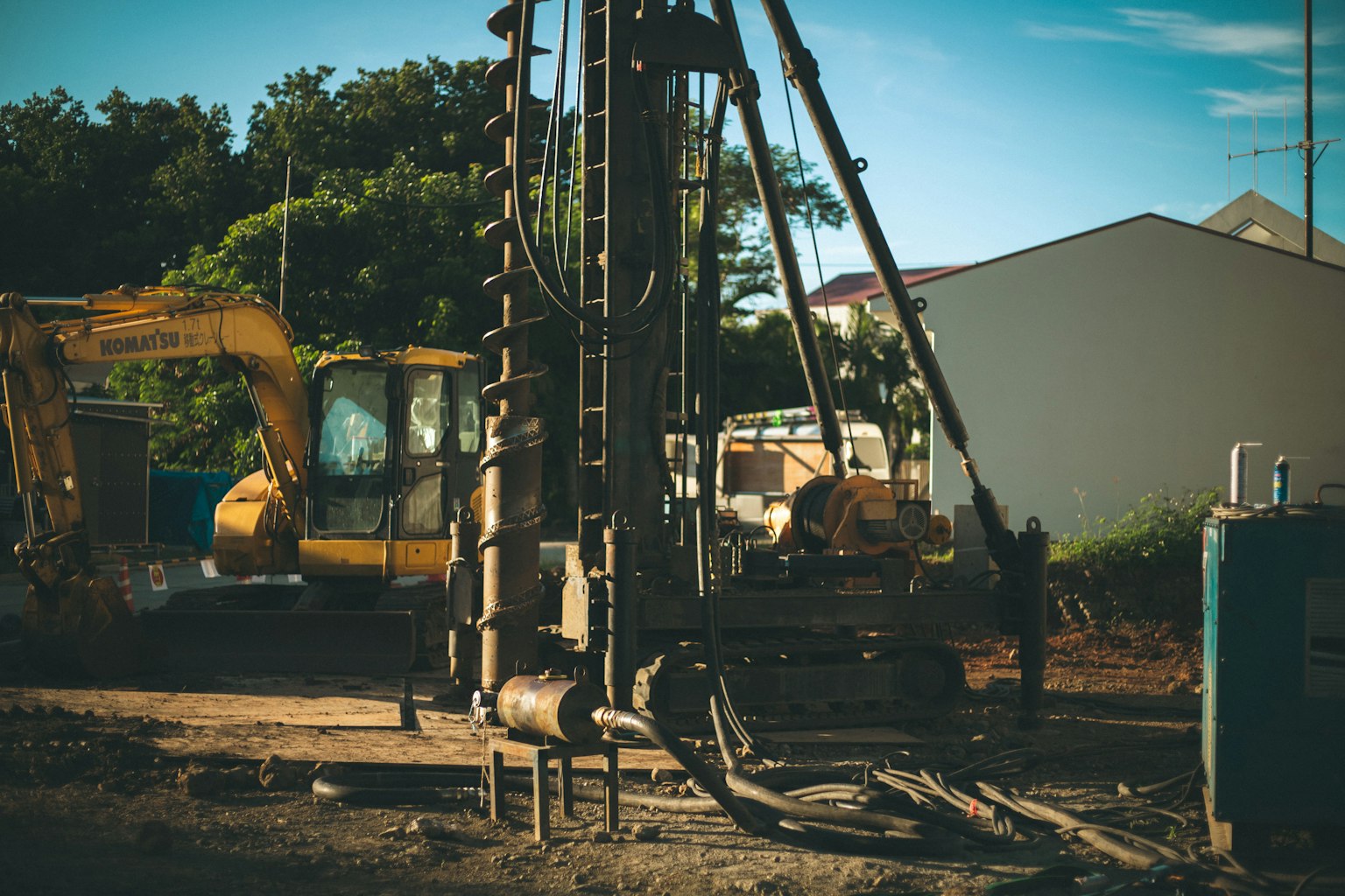 Construction site featuring a drilling rig and heavy machinery