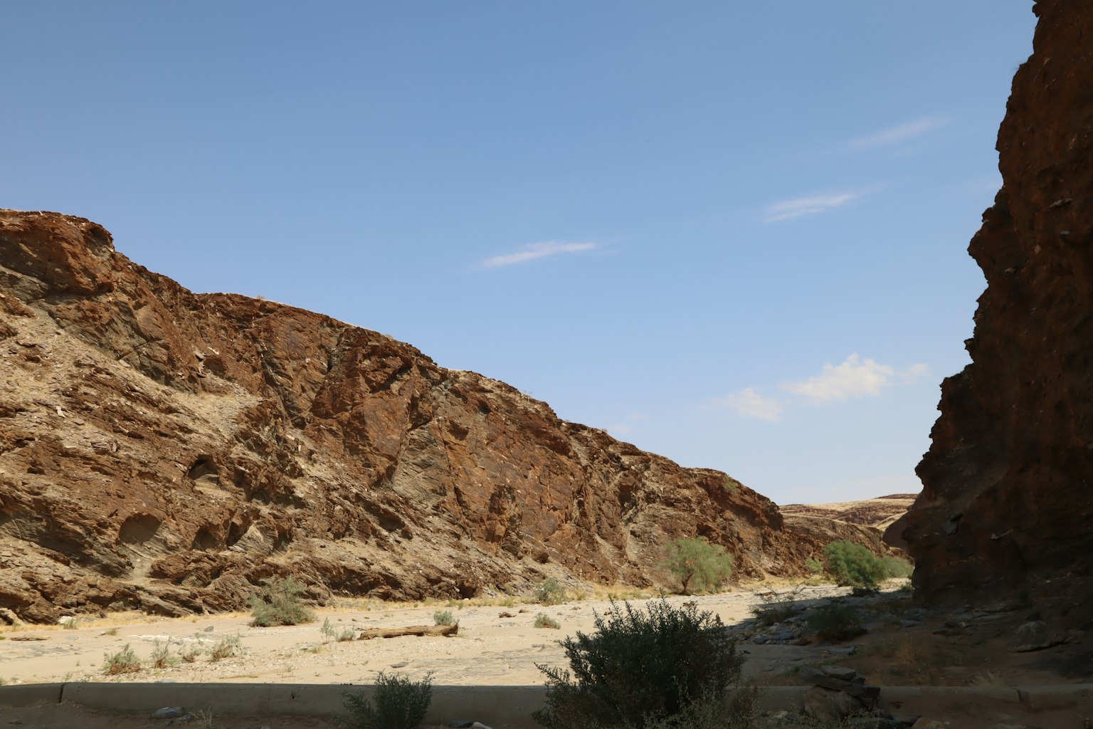 Trockene Canyonlandschaft mit grünen Pflanzen und blauem Himmel