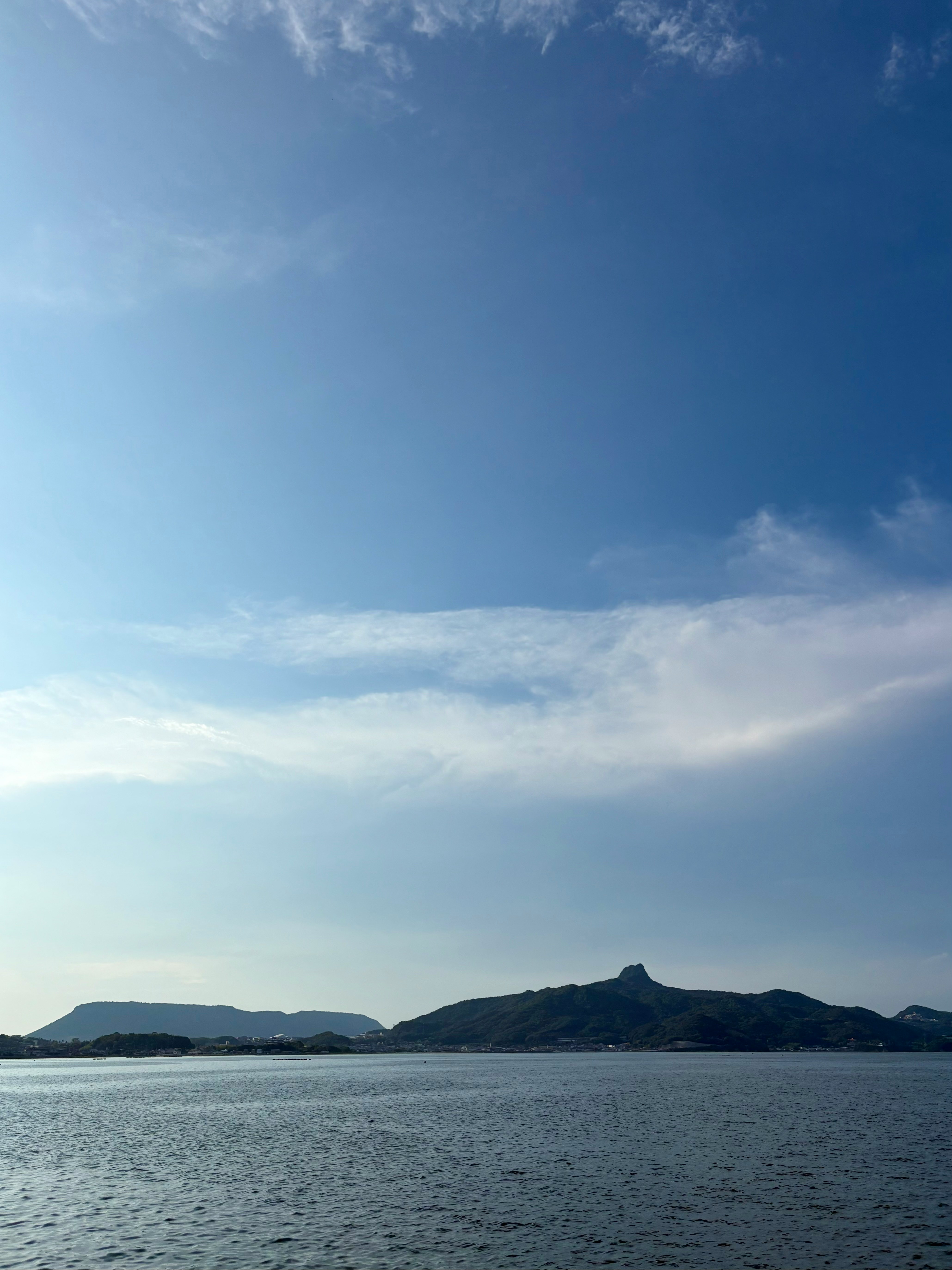 瀬戸内海の海面と屋島・五剣山を望む青空と雲