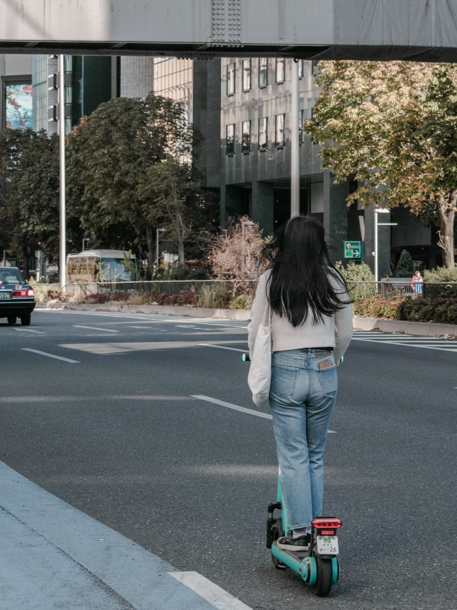 Une femme chevauchant un scooter électrique dans une rue de la ville