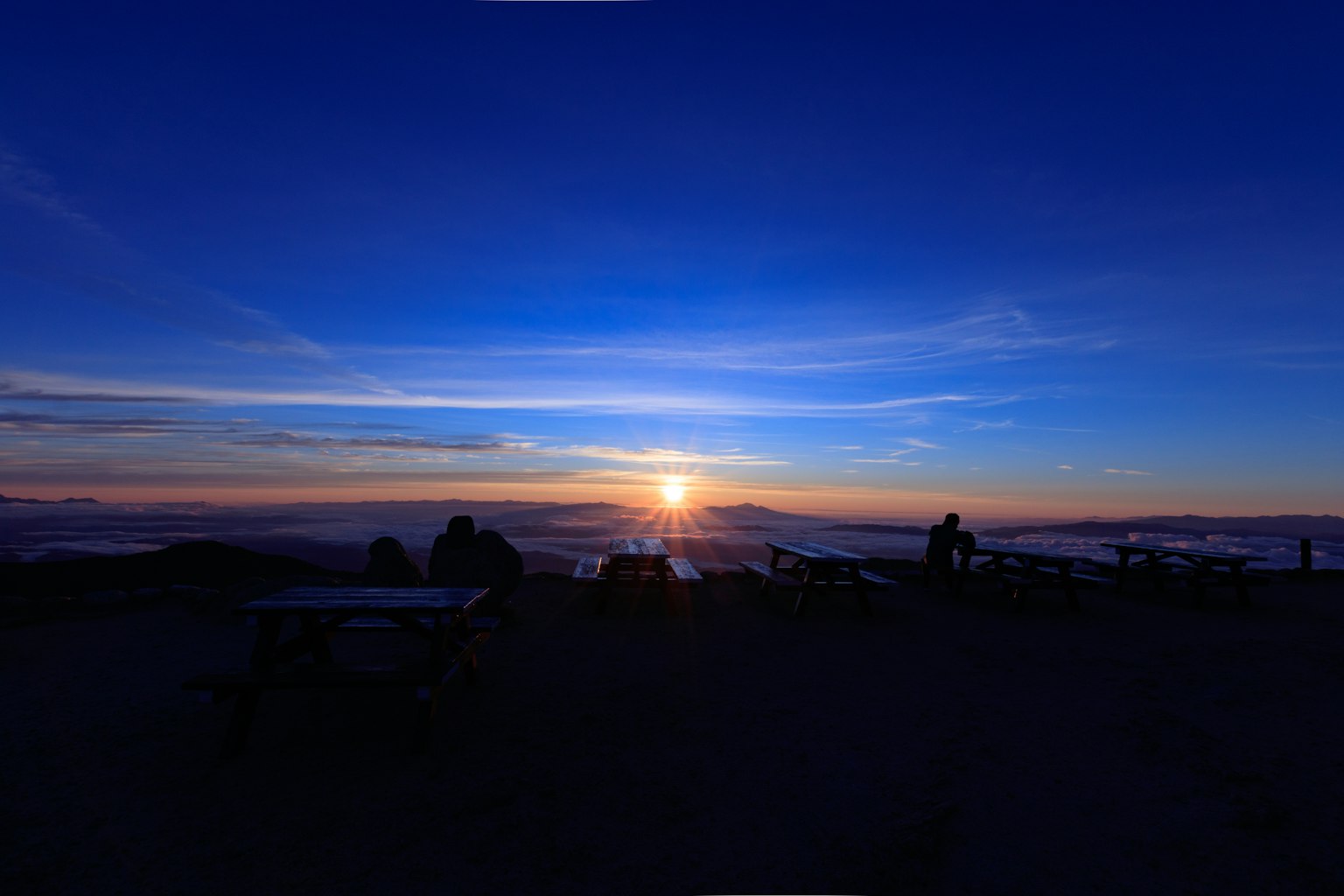 Coucher de soleil magnifique sur un ciel bleu avec des silhouettes de personnes