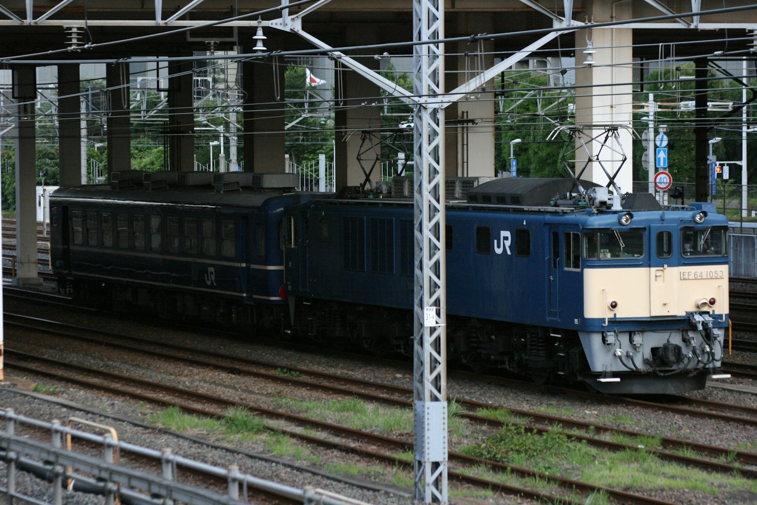 Locomotora JR azul estacionada bajo una estructura ferroviaria