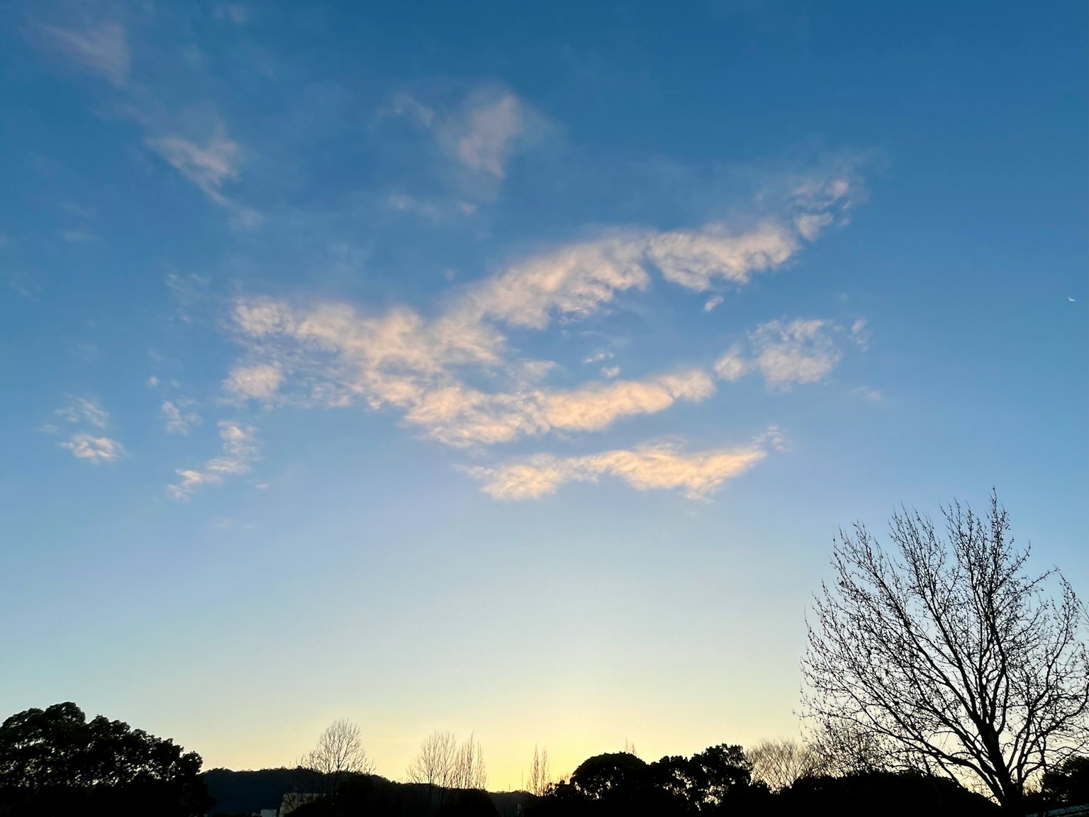 Clear blue sky with wispy clouds and soft evening light
