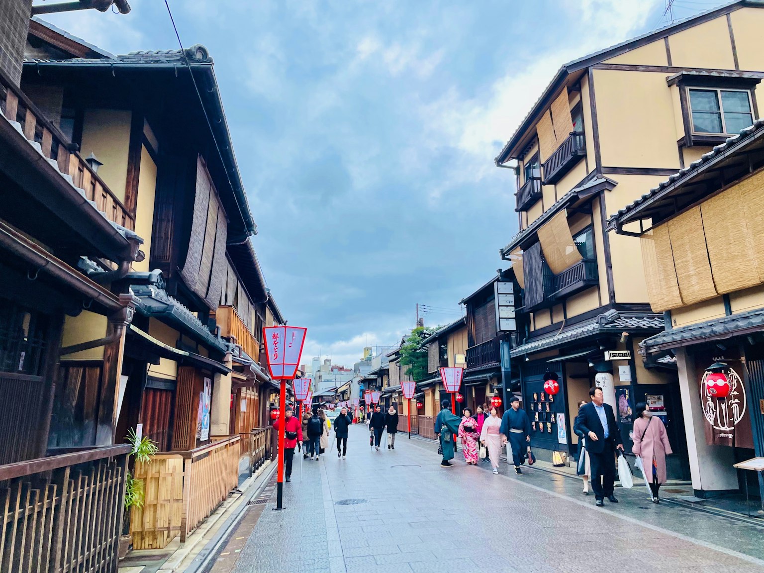 一條風景如畫的街道，有傳統木建築和穿著和服的人