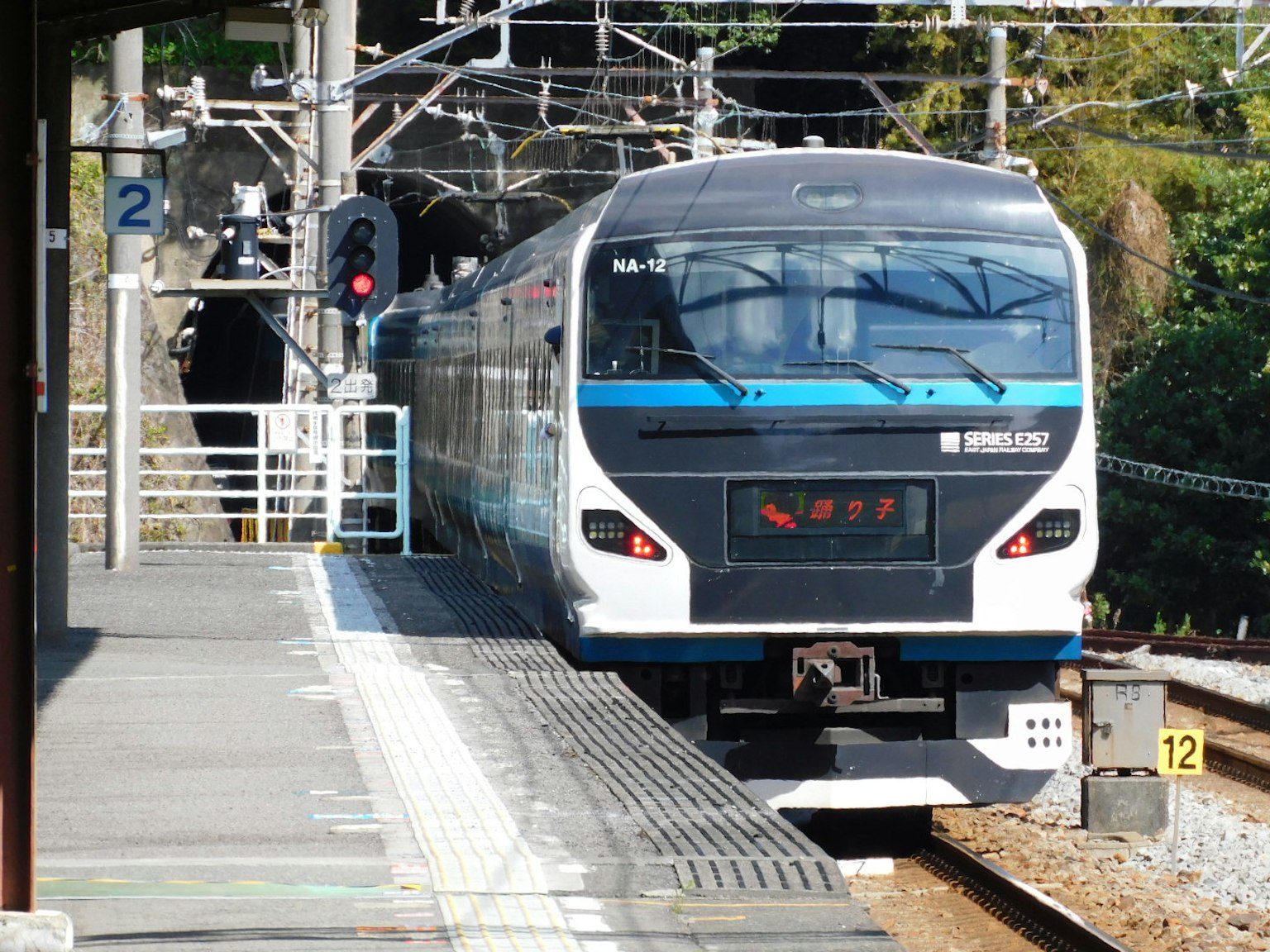 Shinkansen tiba di stasiun dengan platform dan sinyal