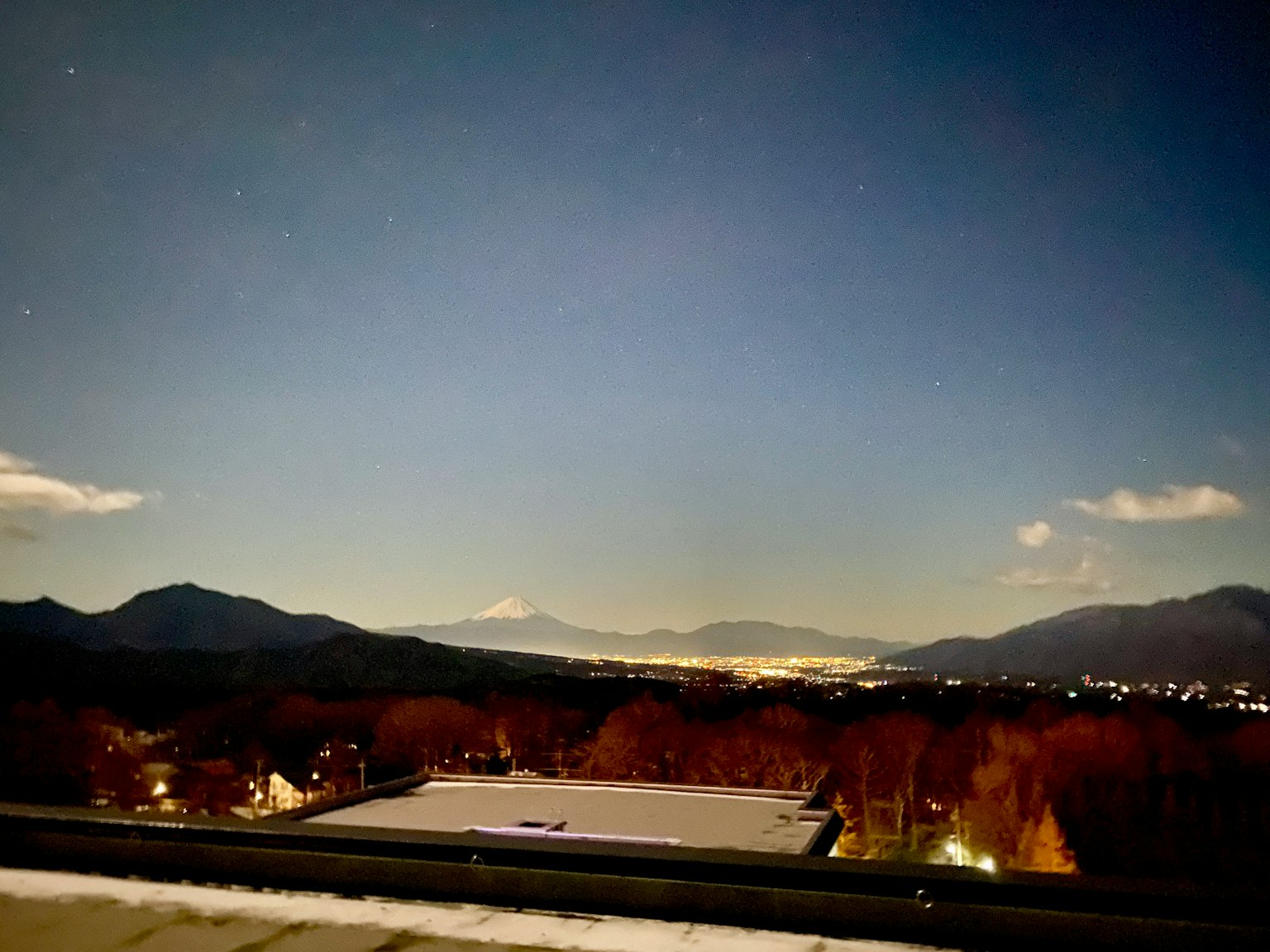 星空下山脈和城市燈光的夜景
