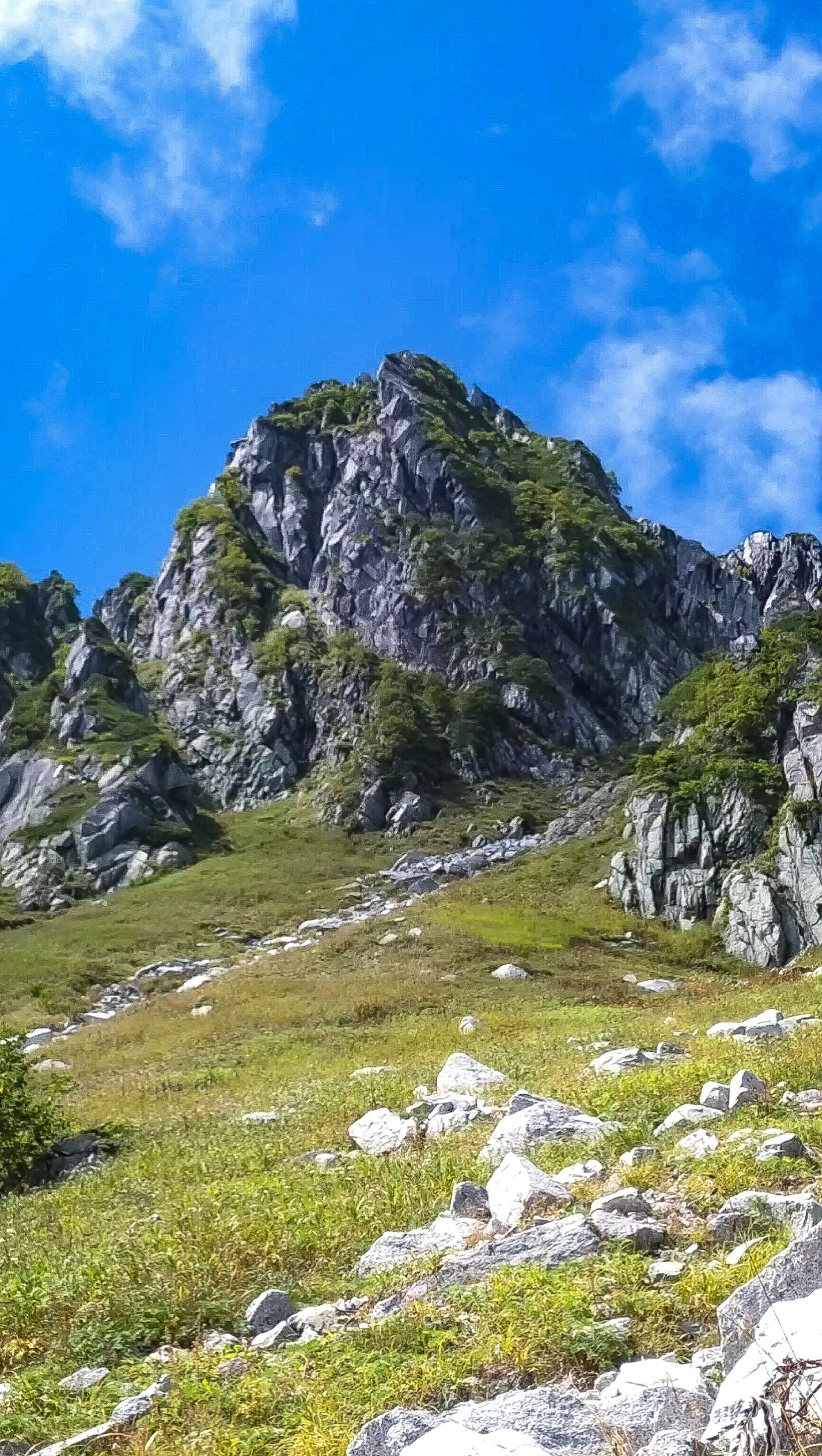 蓝天之下的绿色山丘和岩石山