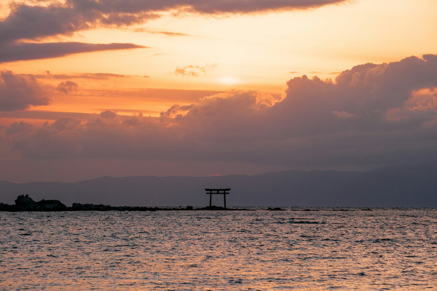 Bellissimo tramonto sull'oceano con la silhouette di un torii