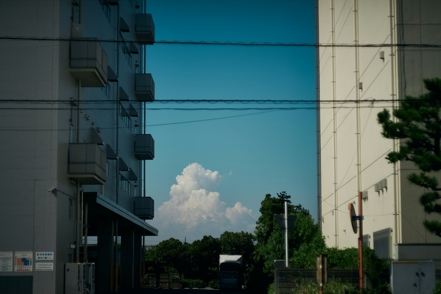 Blick zwischen zwei Gebäuden mit blauem Himmel und fluffigen Wolken im Hintergrund
