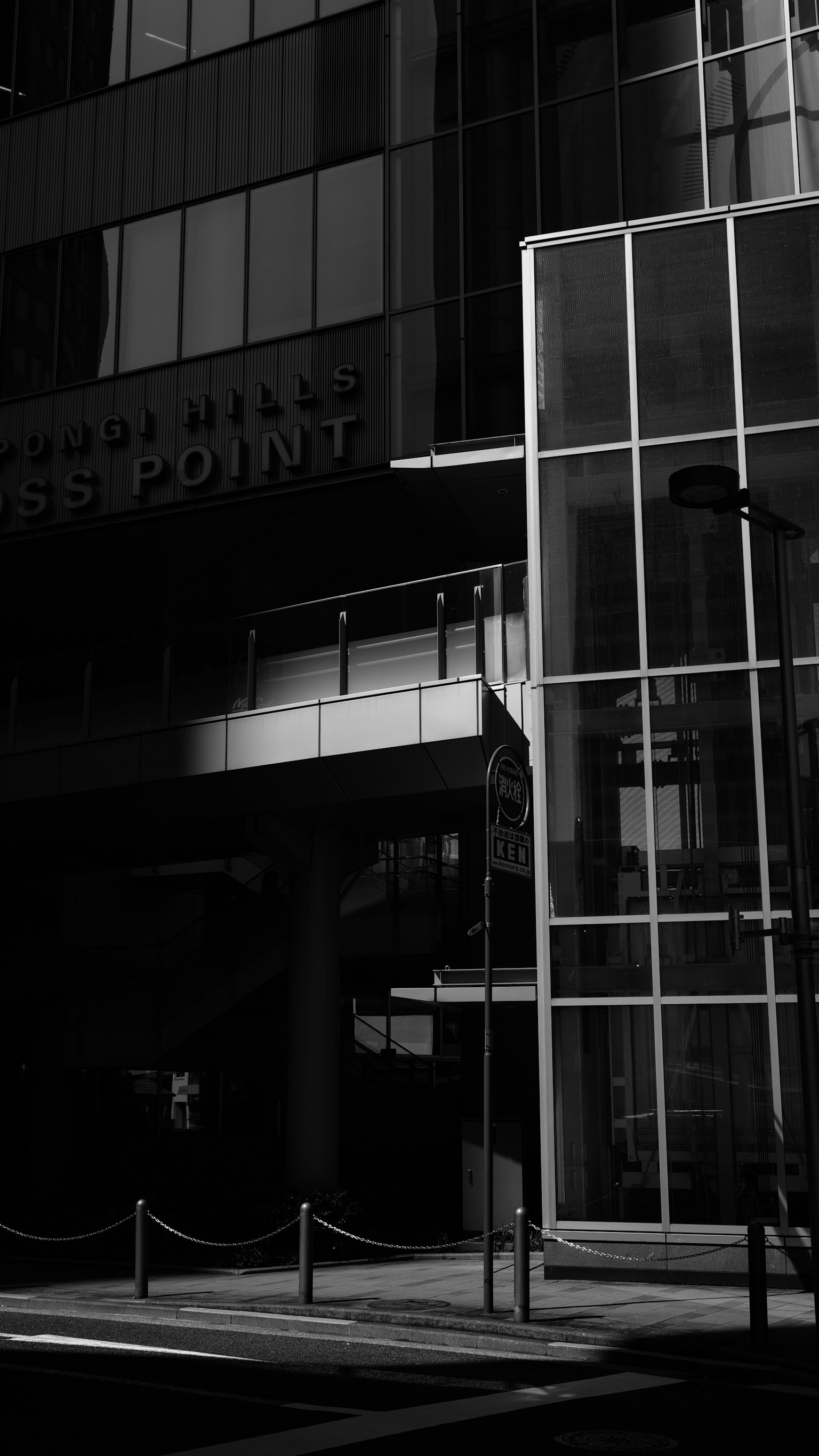 Extérieur d'un bâtiment moderne avec un fort contraste noir et blanc présentant une façade en verre et une structure en métal