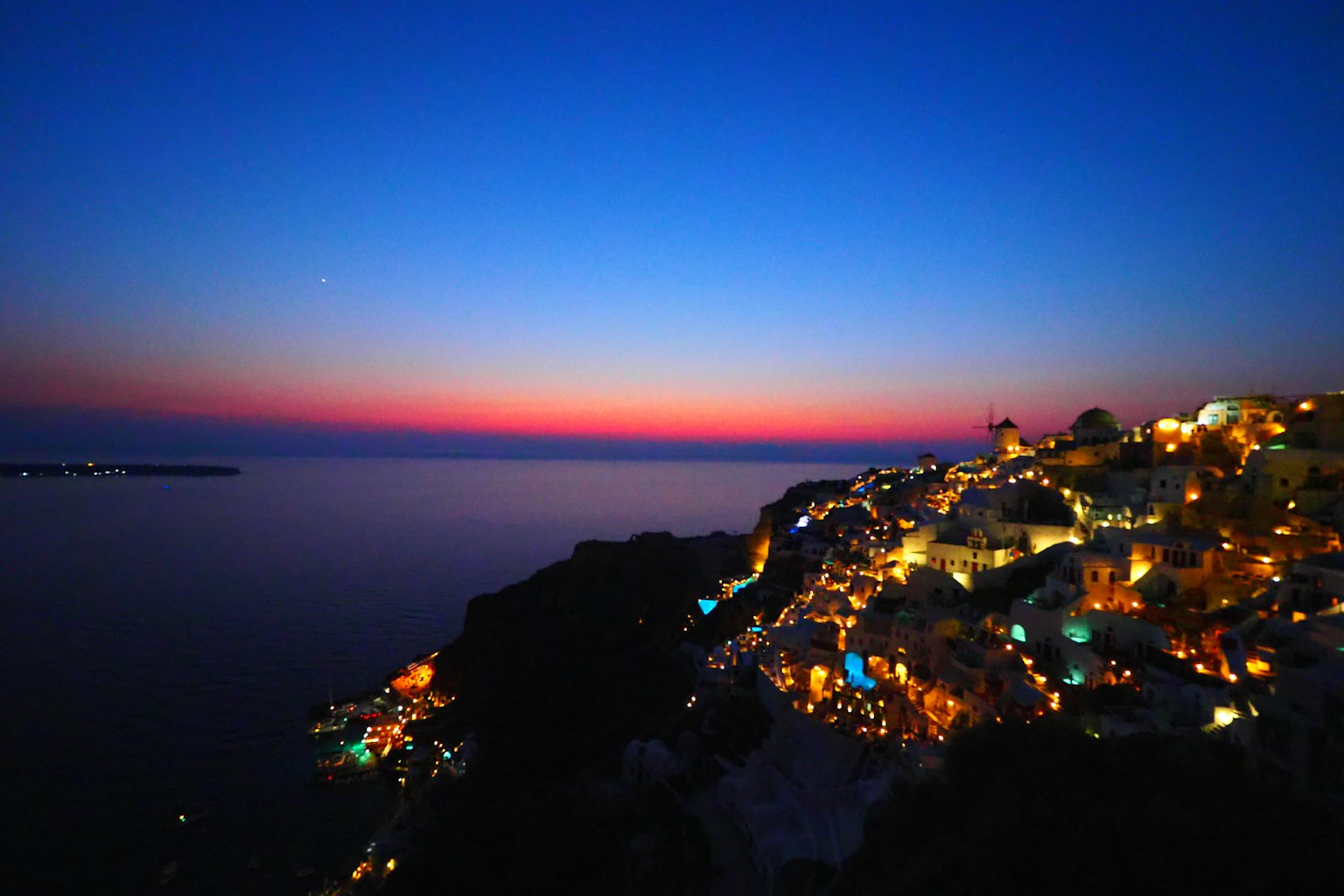 Magnifique ciel au coucher du soleil et vue sur la mer illuminée par les lumières de la ville