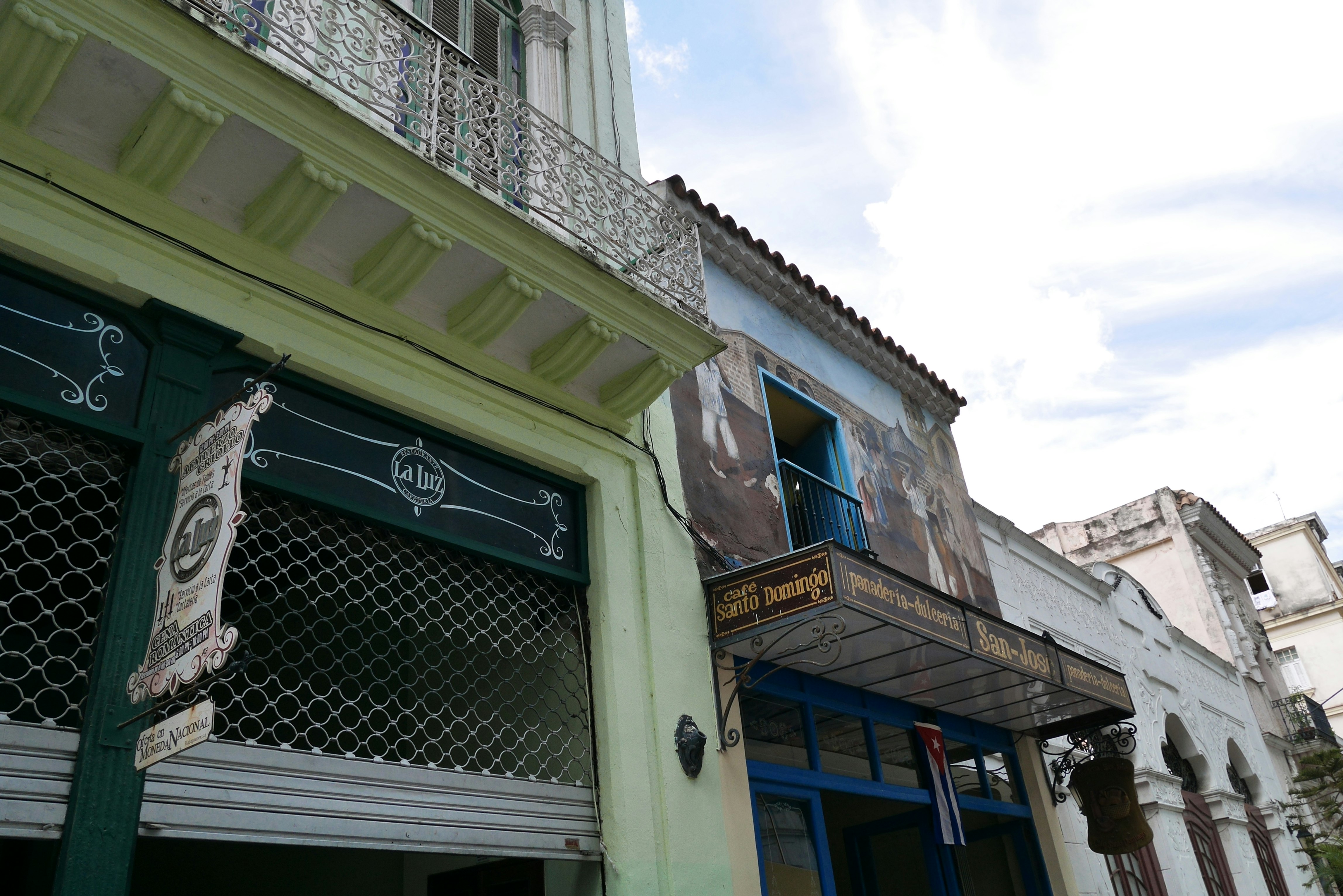 Esquina de calle con edificios antiguos y letreros de tiendas