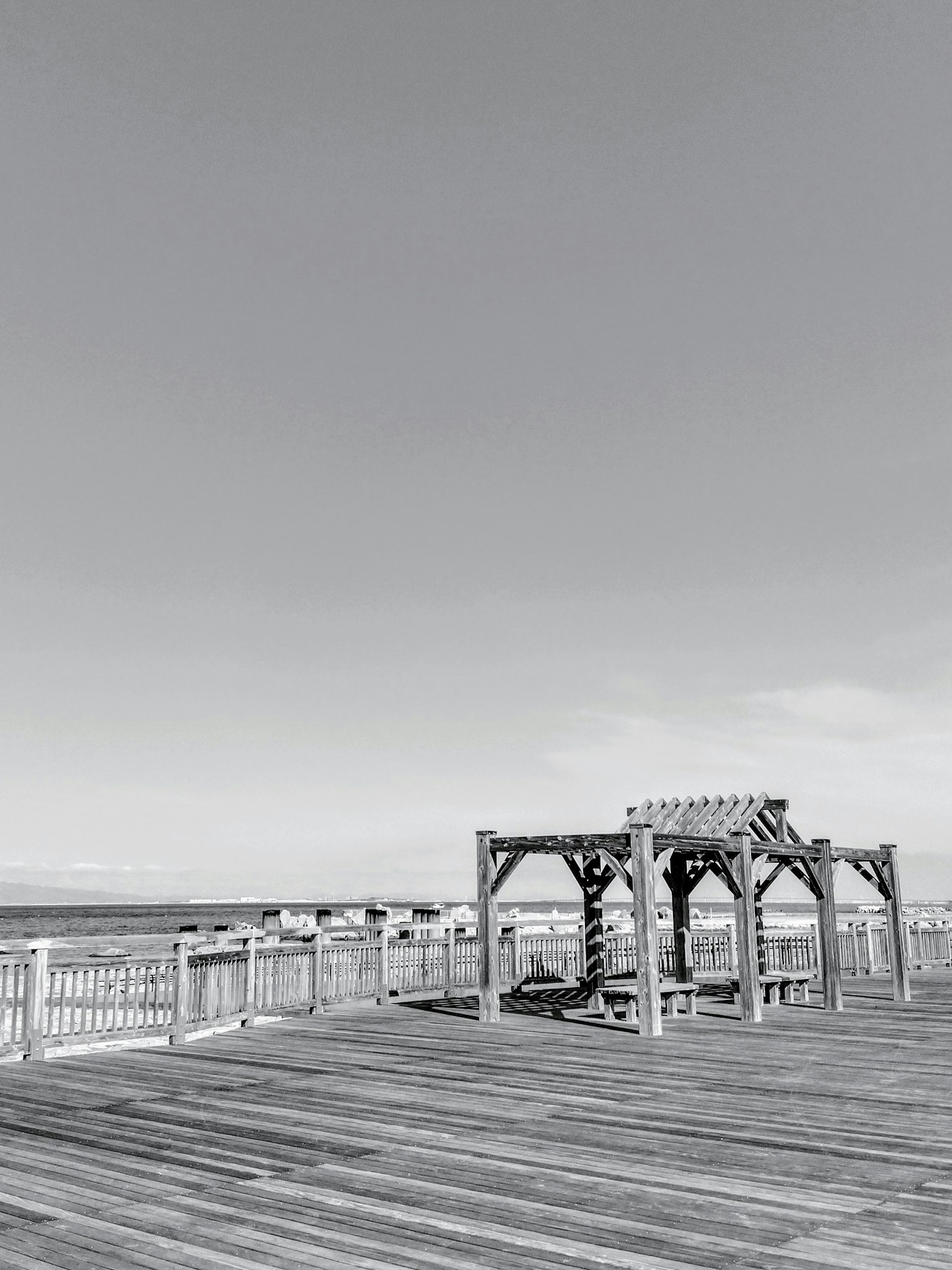 Wooden deck featuring a pergola and benches