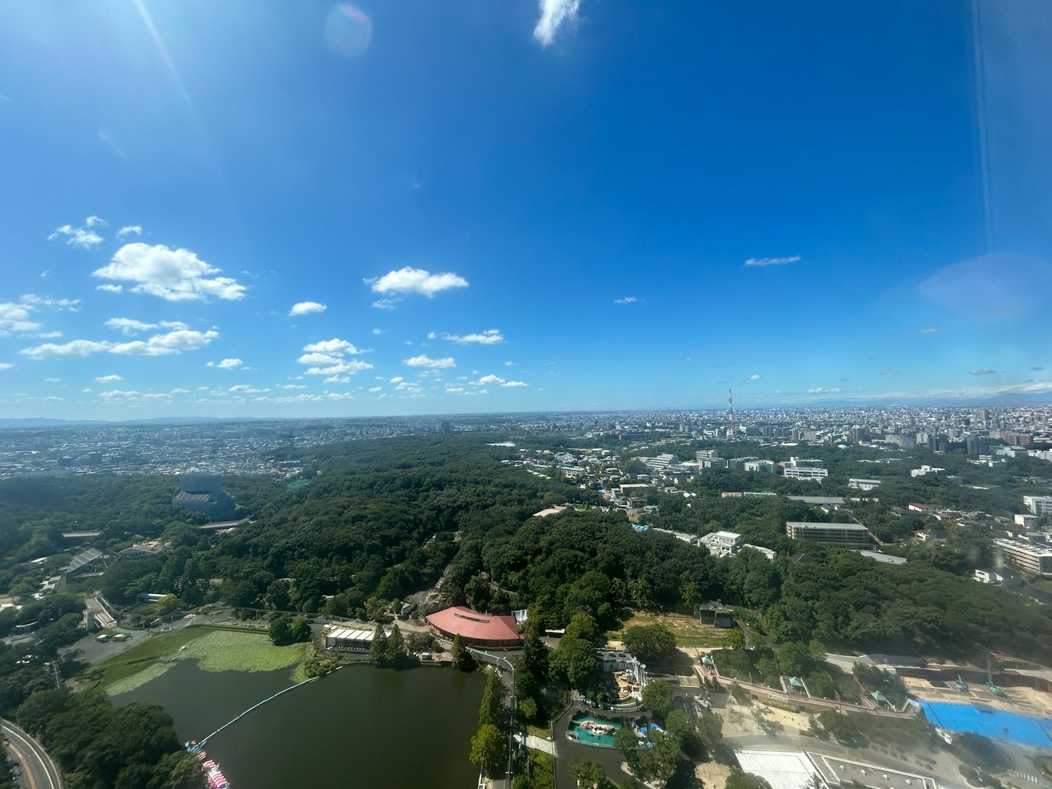 ทิวทัศน์เมืองใต้ท้องฟ้าสีฟ้าพร้อมสวนสีเขียวและทะเลสาบ