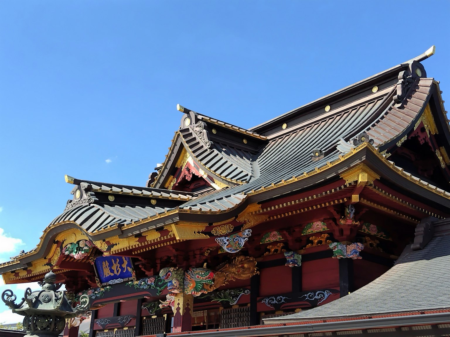Traditional Japanese shrine with vibrant roof and intricate decorations