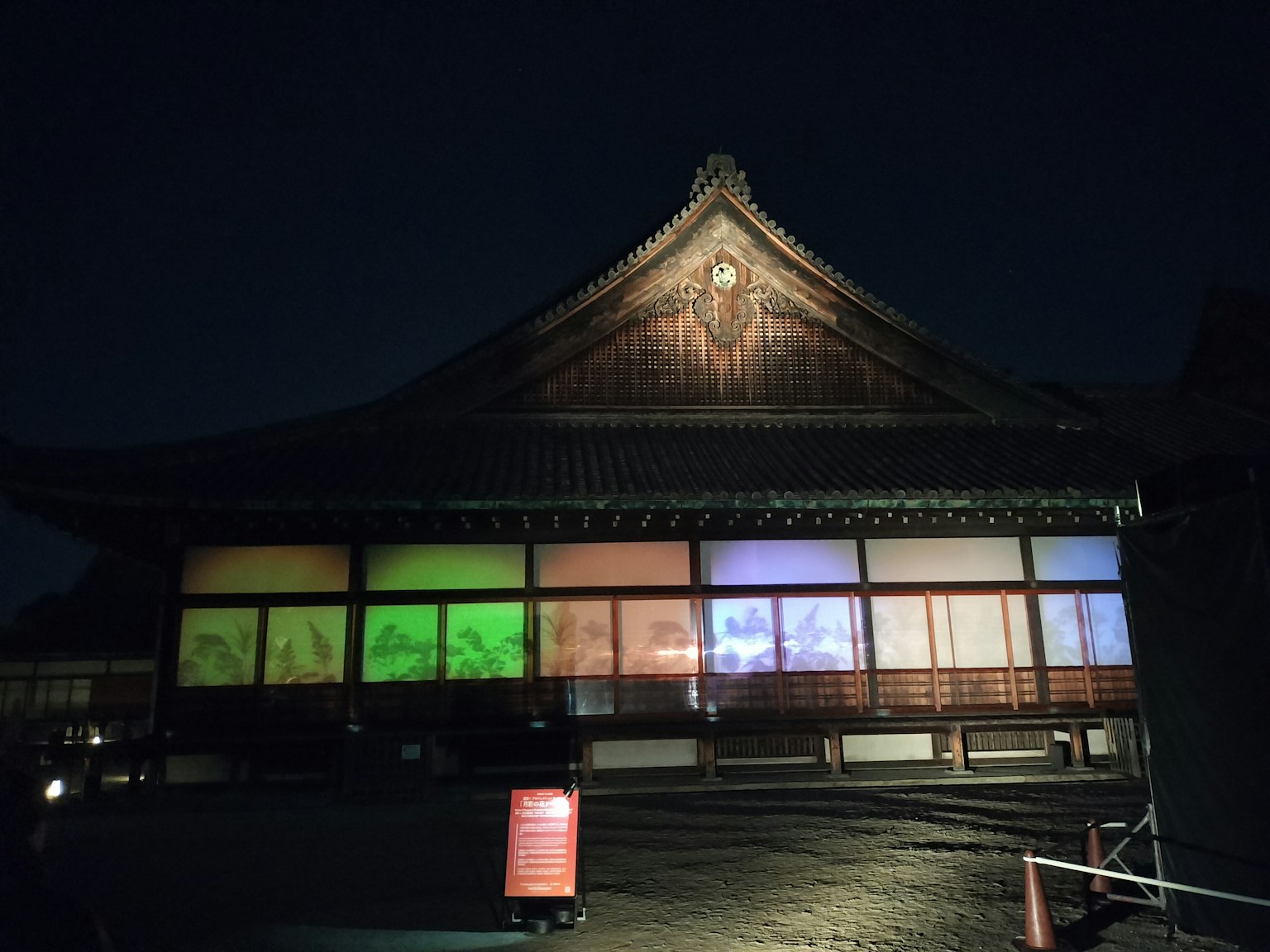 Traditionelles japanisches Gebäude bei Nacht mit bunten Fenstern beleuchtet